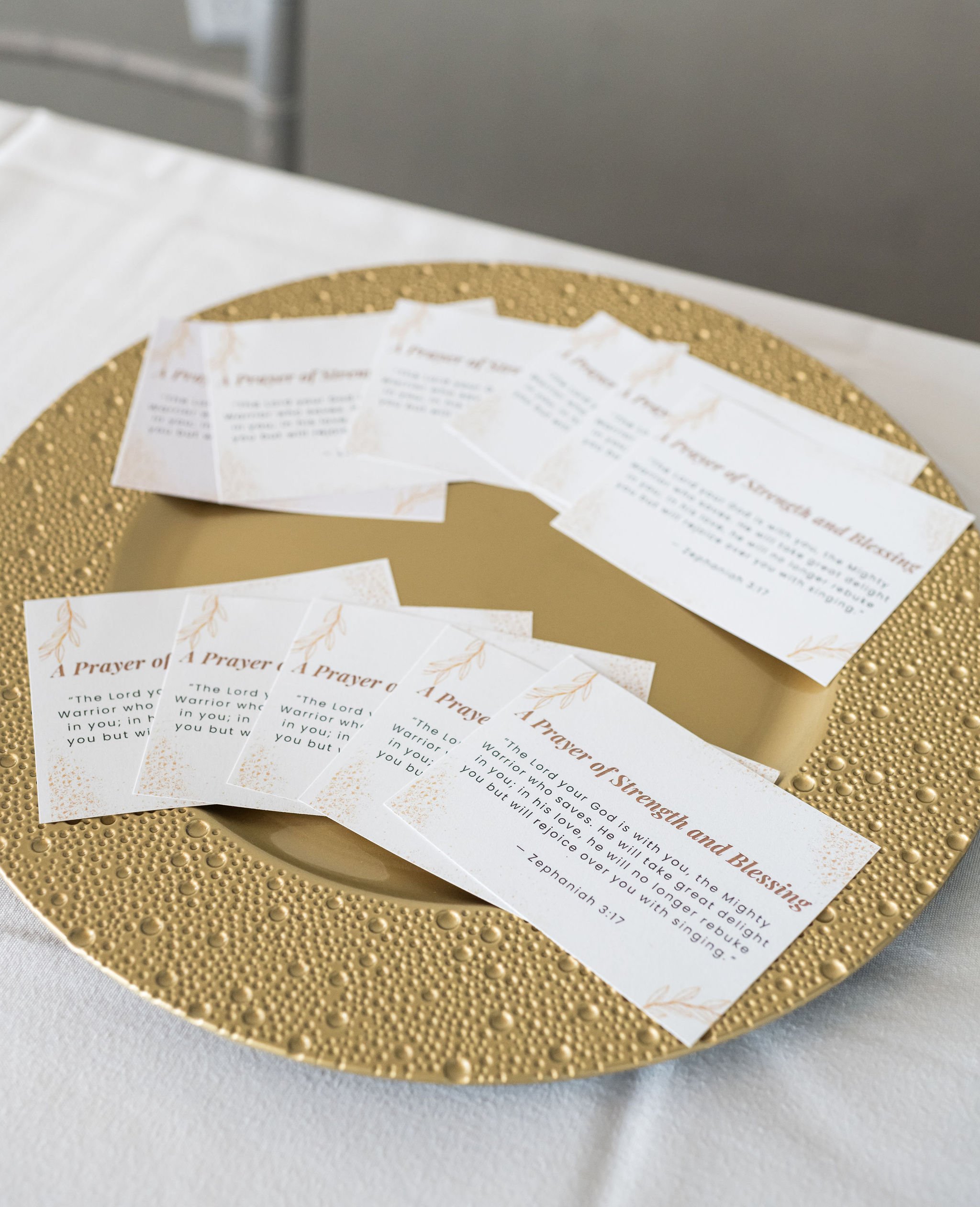 Gold plate with prayer cards on a table.