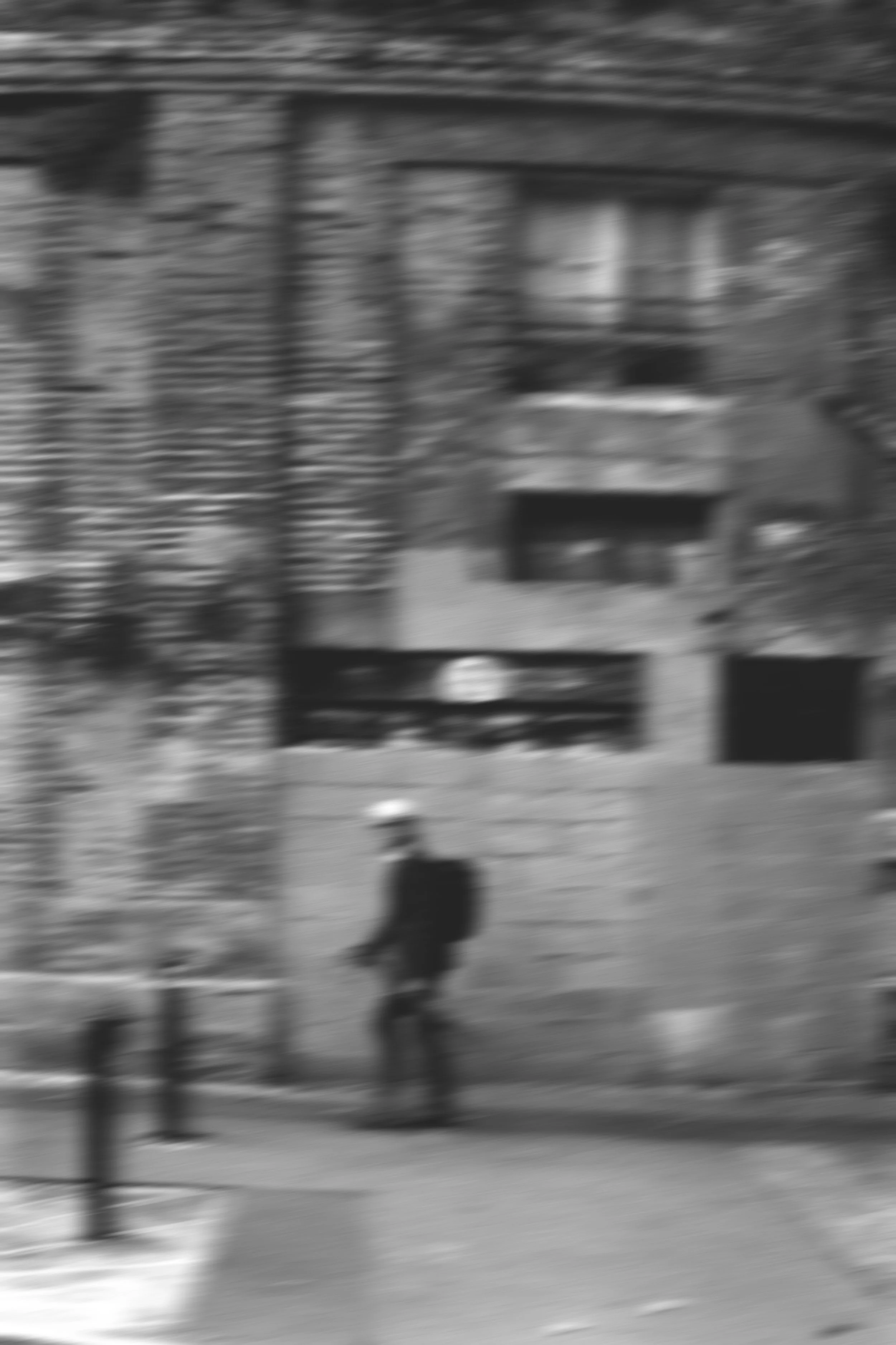 Photo floue d'une personne marchant dans une rue avec des bâtiments résidentiels en arrière-plan. Editorial