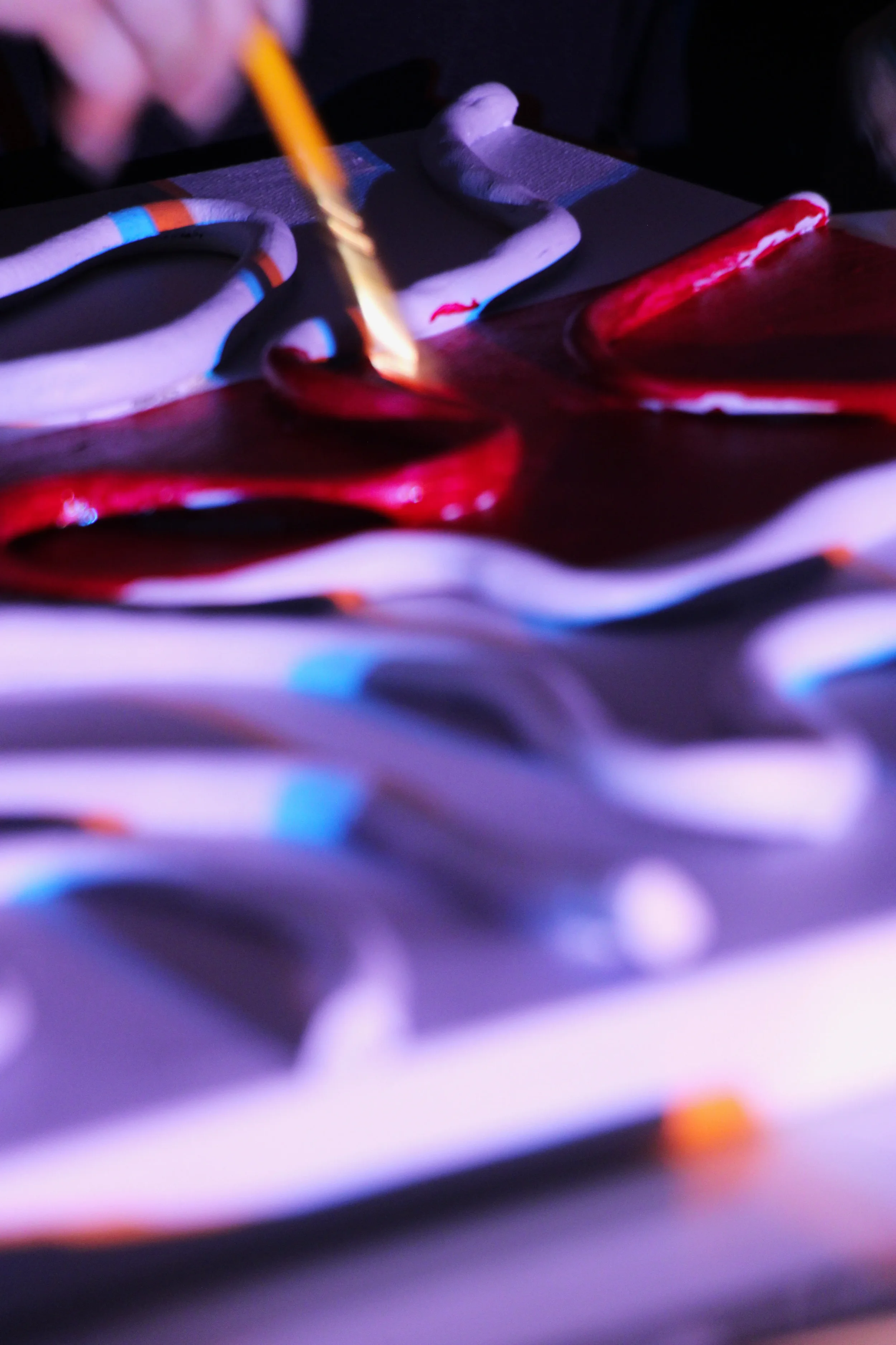 Une peinture abstraite avec des couleurs vives, notamment du rouge, du bleu, du violet et du blanc, réalisée avec des coups de pinceau apparemment rapides et expressifs.