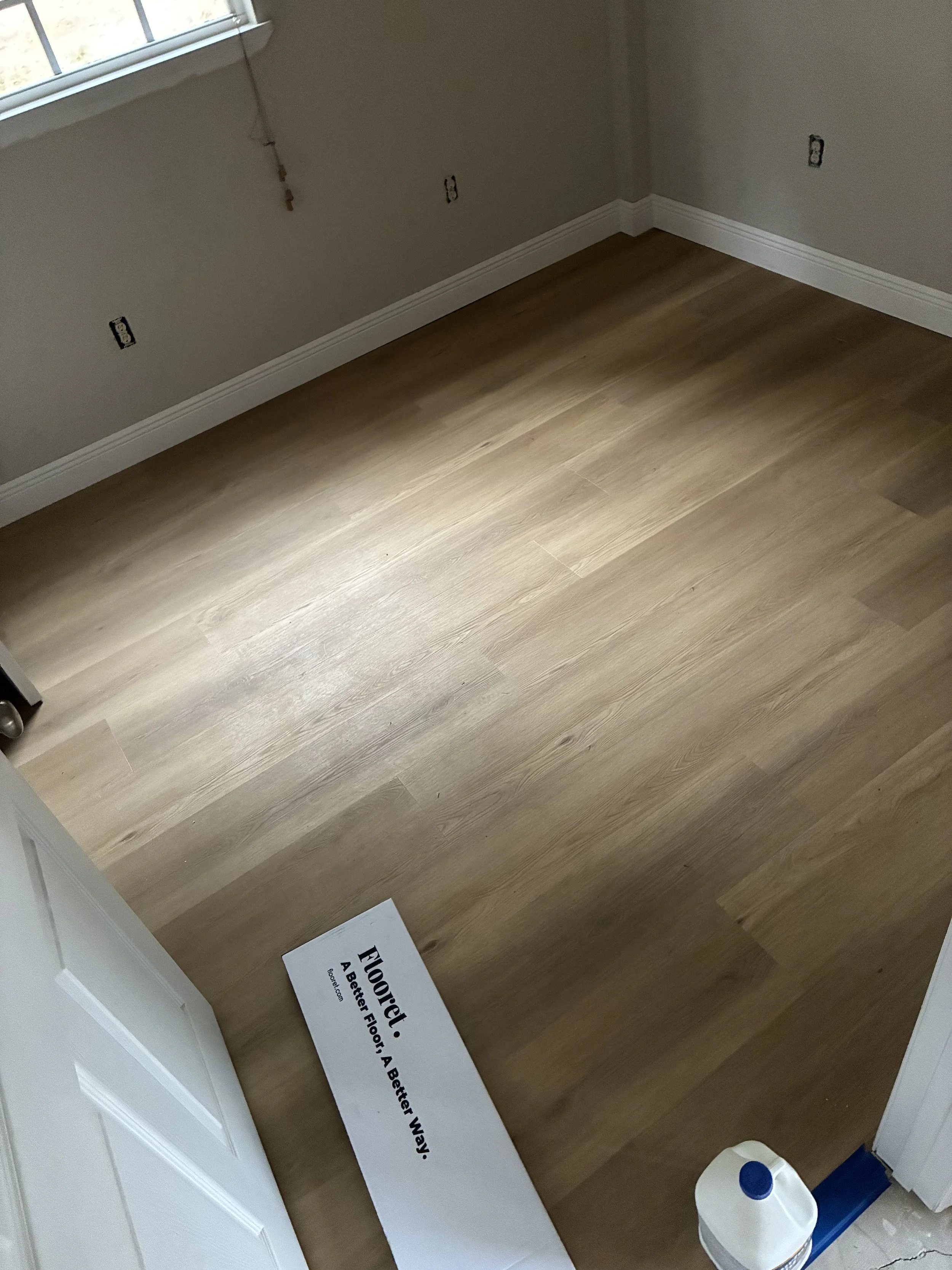 Completed LVP flooring installation in Dade City living room with new baseboards by Own Style