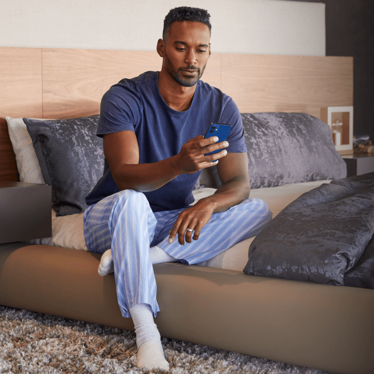 Man waking up in bed using the Savant Pro app