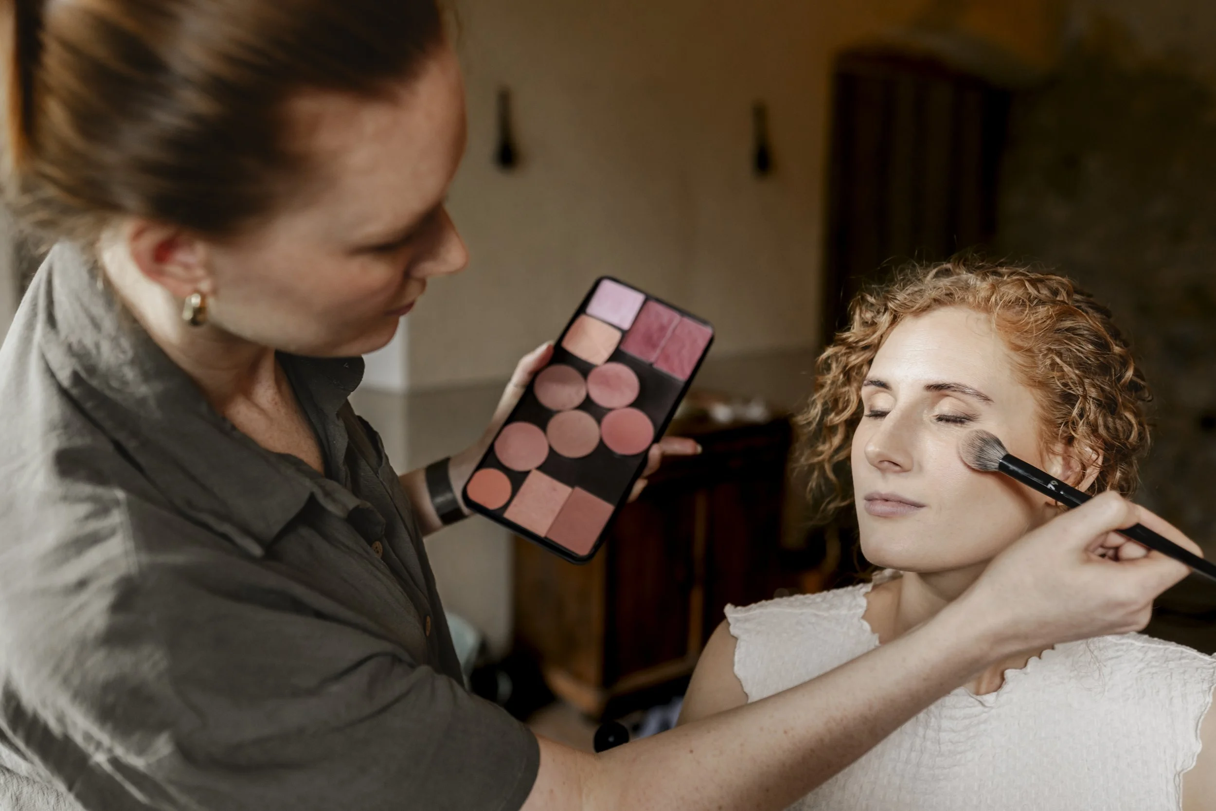 Ann Fox beim auftragen von Blush bei einer Braut mit Locken beim Styling