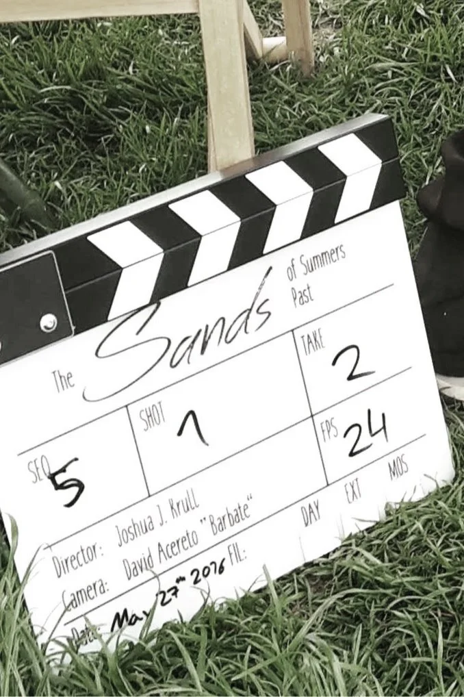 Klipboard mit Drehbuch für einen Kurzfilm namens "The Sands of Summers Past" auf einem Rasen.