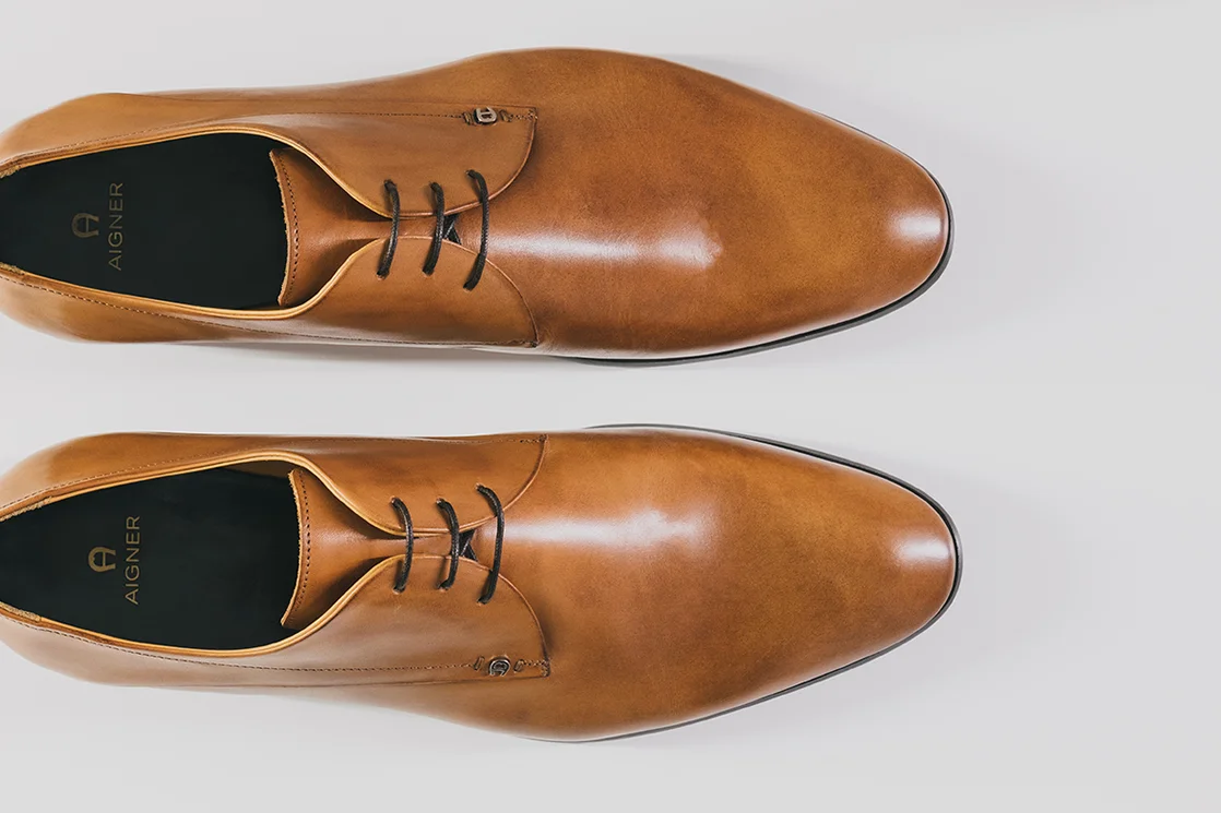Braune Lederschuhe von oben auf hellem Hintergrund.