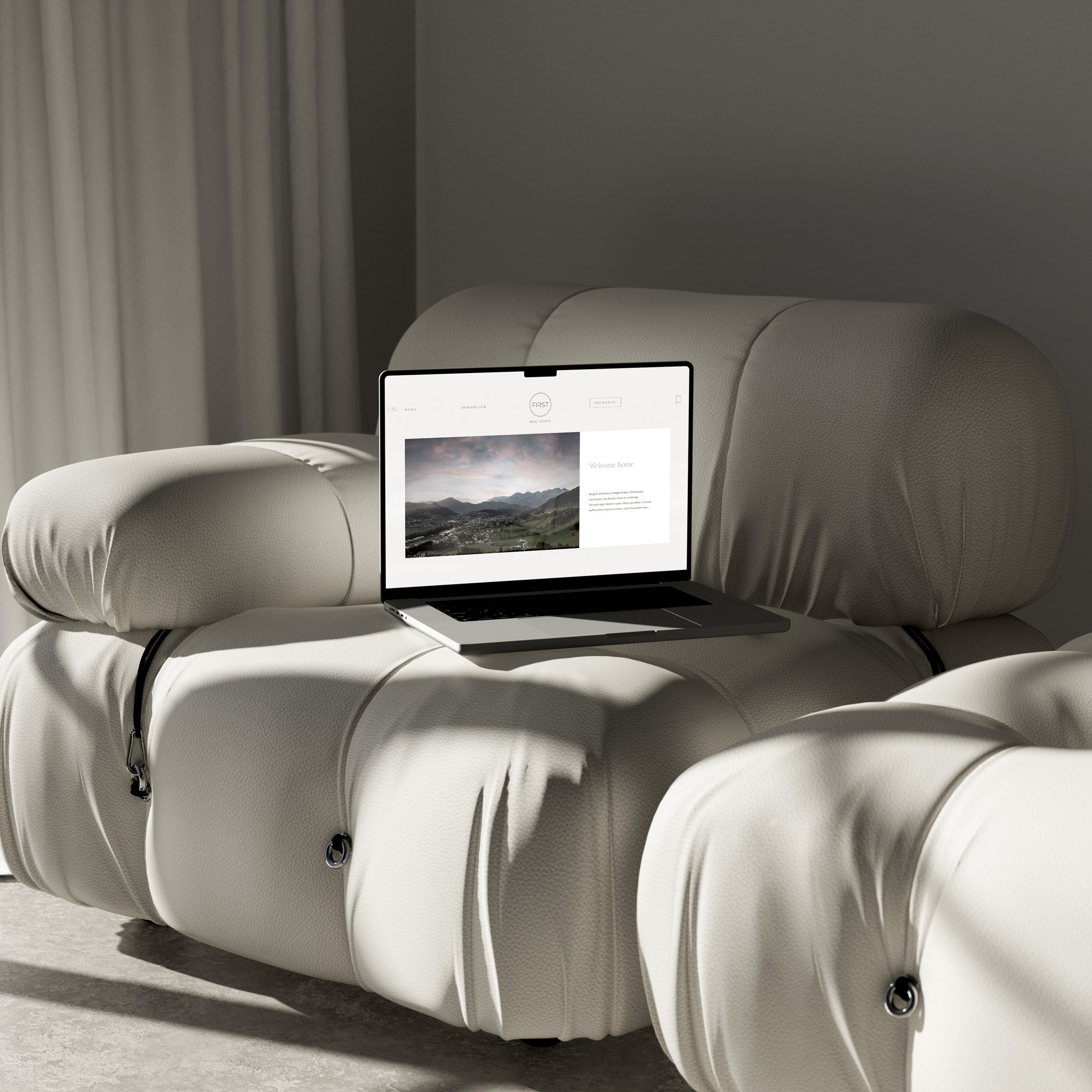 Ein Laptop auf einem hellen, gepolsterten Sofa in einem minimalistisch eingerichteten Raum.