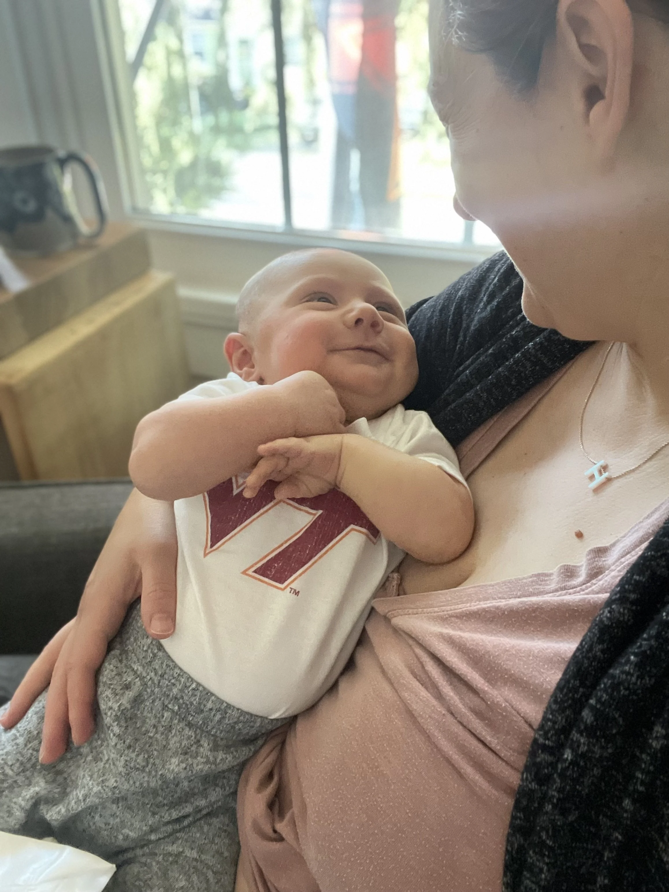 baby smiling while looking at mom