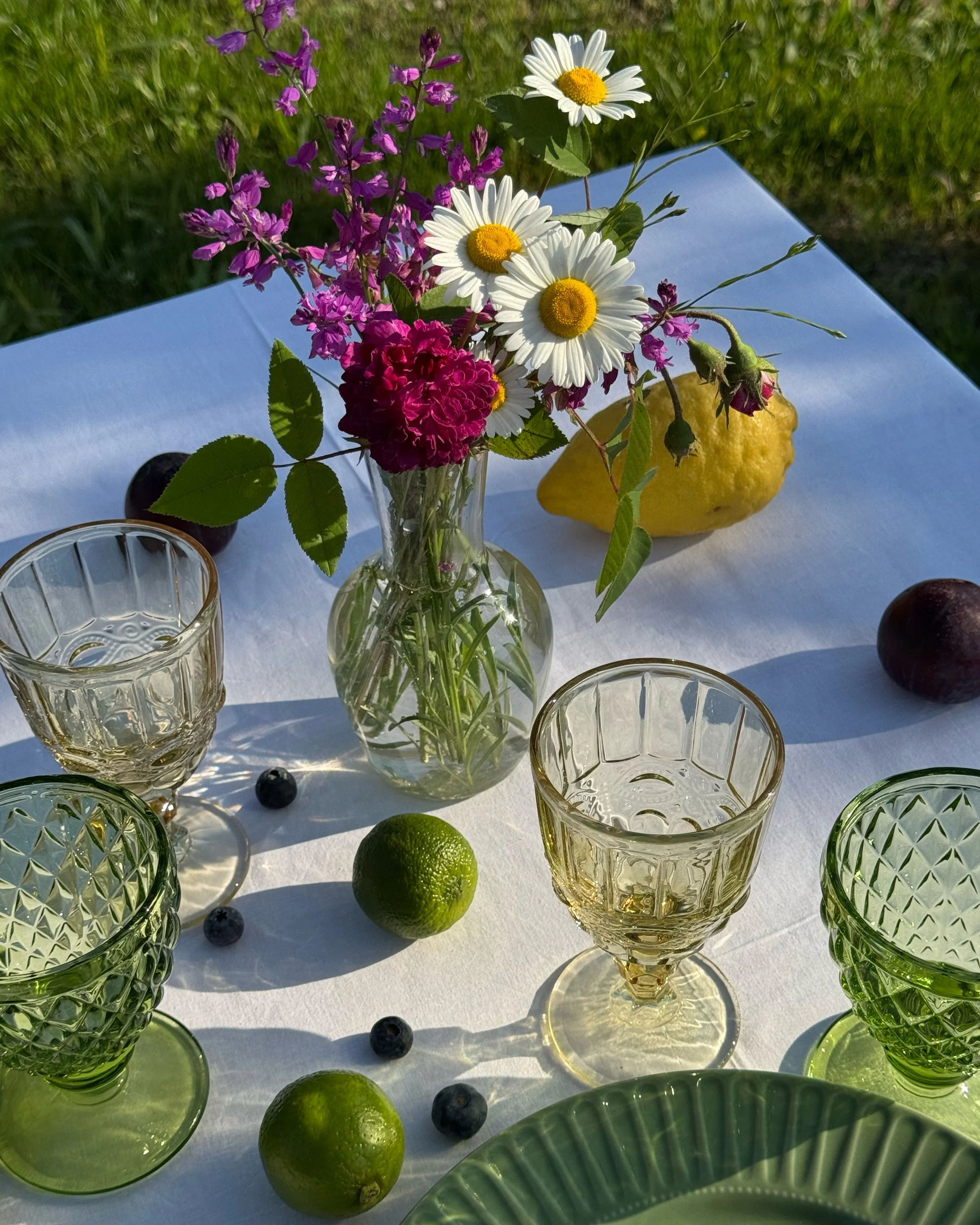 Ricca e elegante tavola imbandita con fiori e frutti colorati