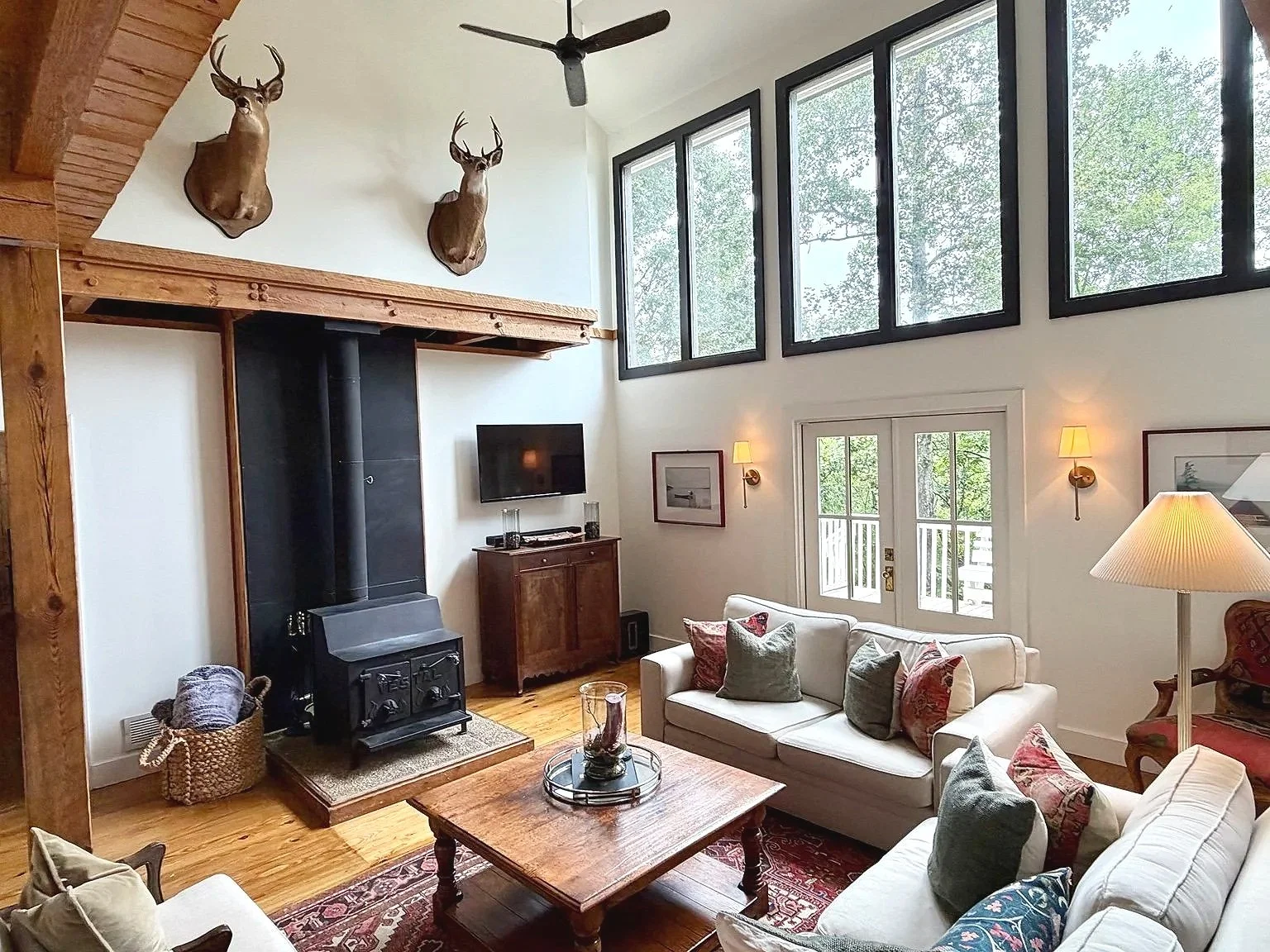 Tall windows fill Pine Shore Lodge’s living room with natural light.