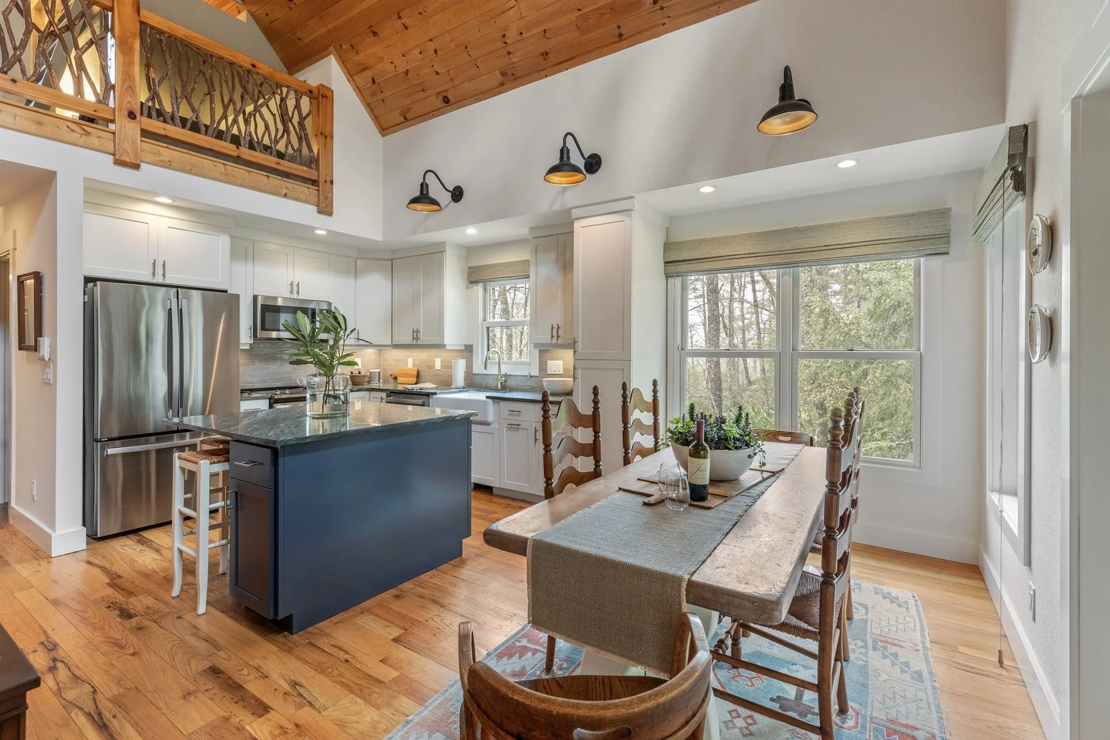 Creekwood Cottage’s kitchen and dining area beneath a warm timber ceiling.