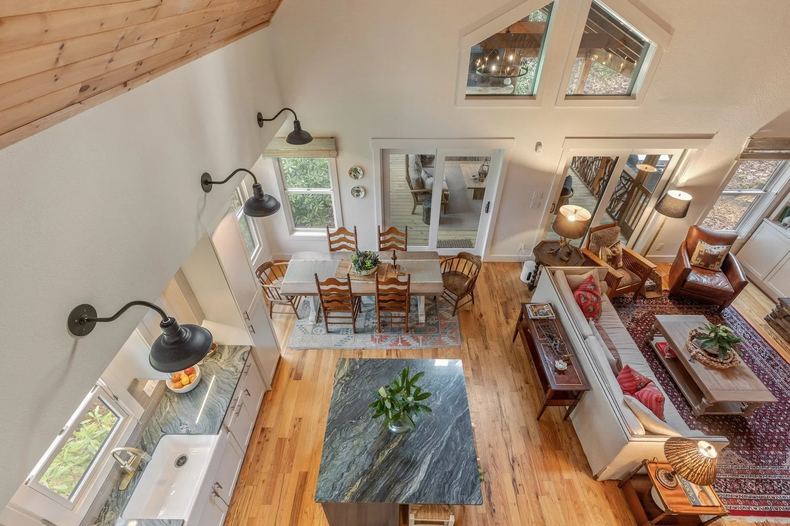 The view from Creekwood Cottage’s loft into its vaulted living and dining spaces.