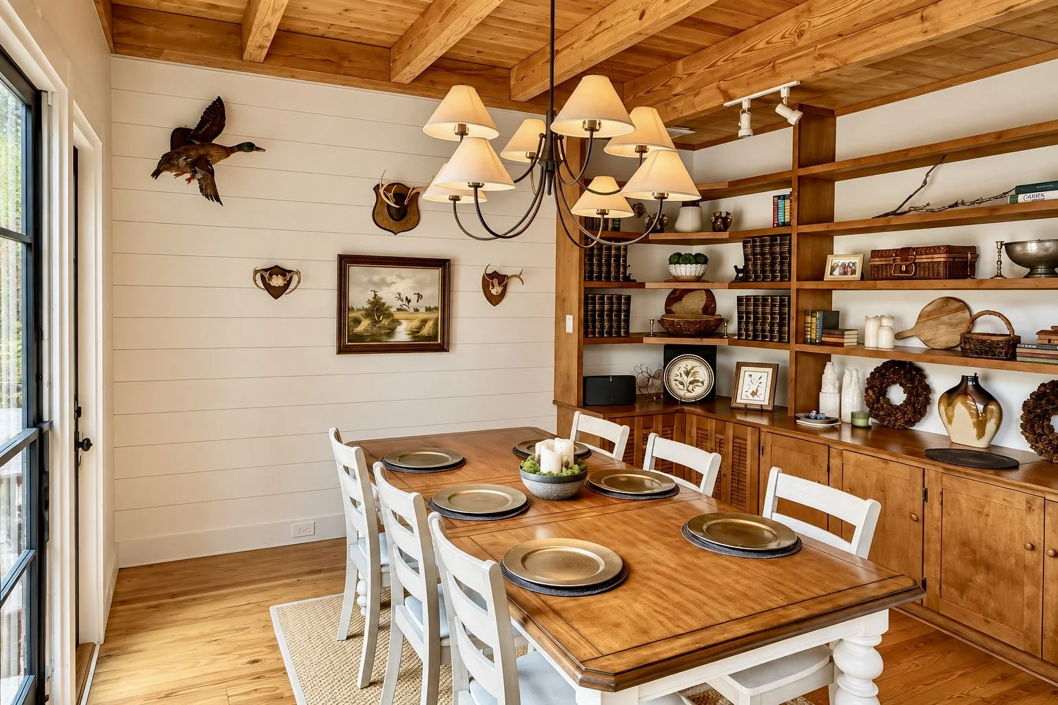 The dining room at Pine Shore Lodge, with a timber ceiling, a long dining table, and built-in shelves.