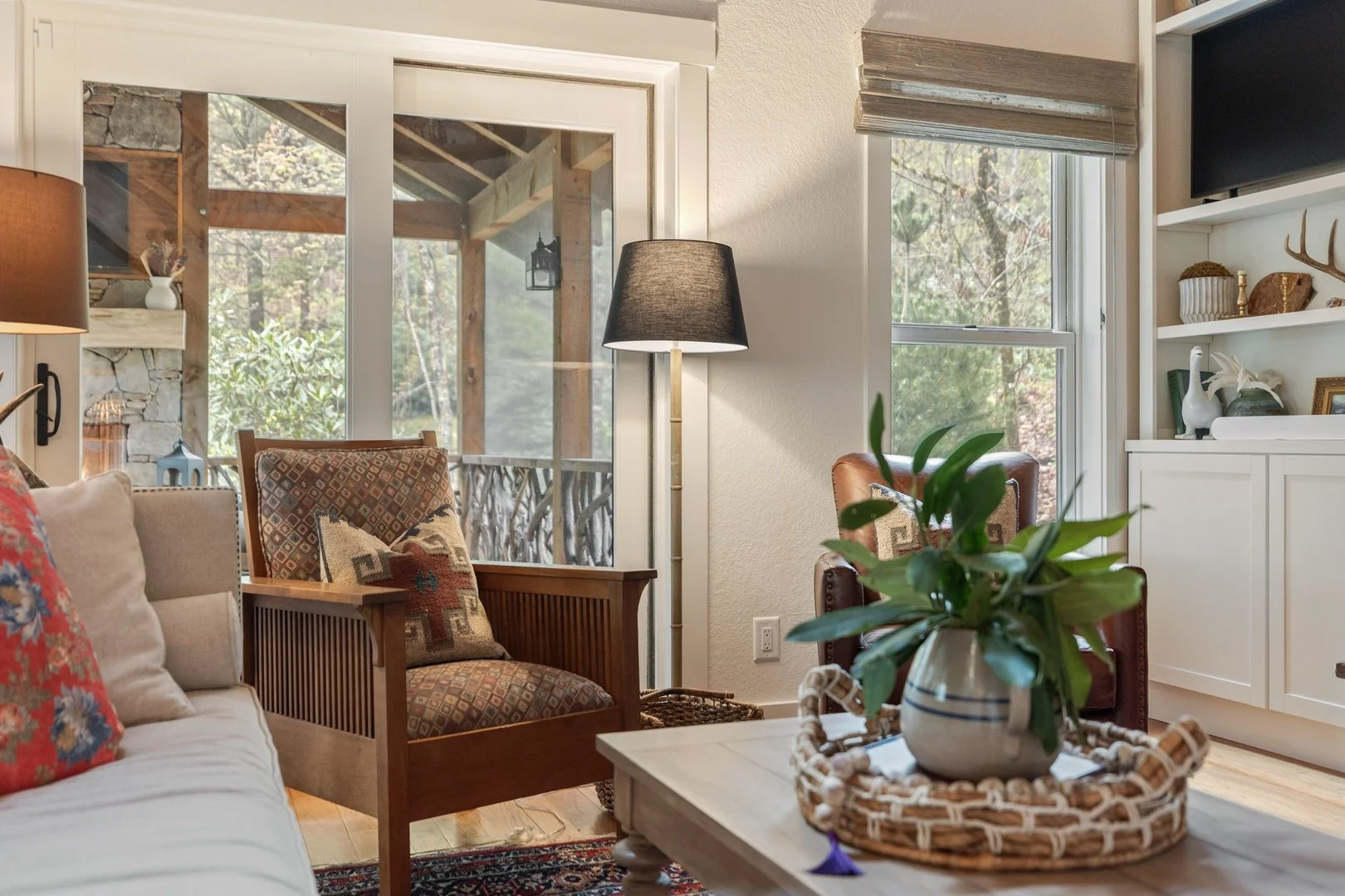 An inviting Creekwood Cottage sitting room with views through the screened porch.