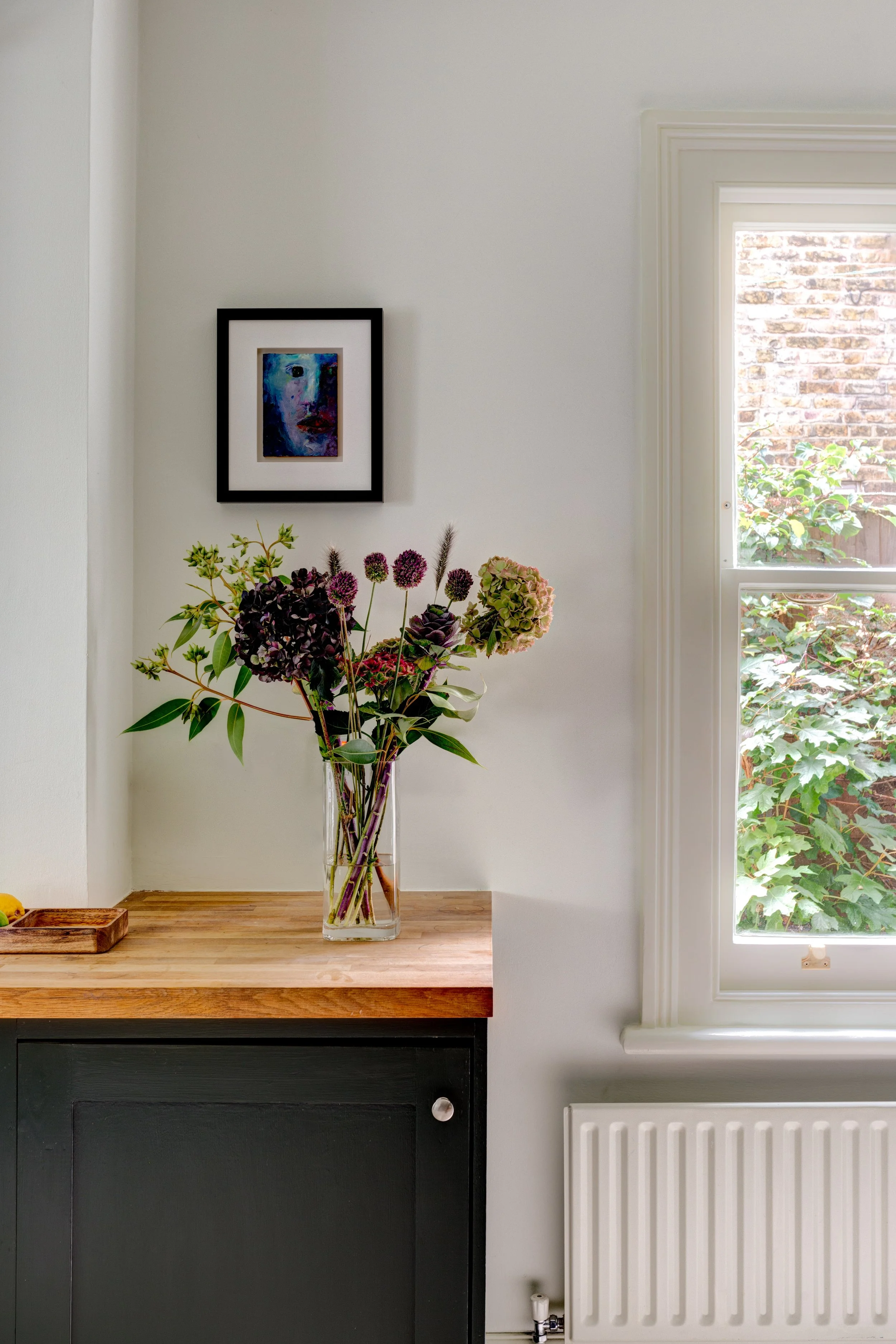Interior with elegant vase of flowers and artwork.