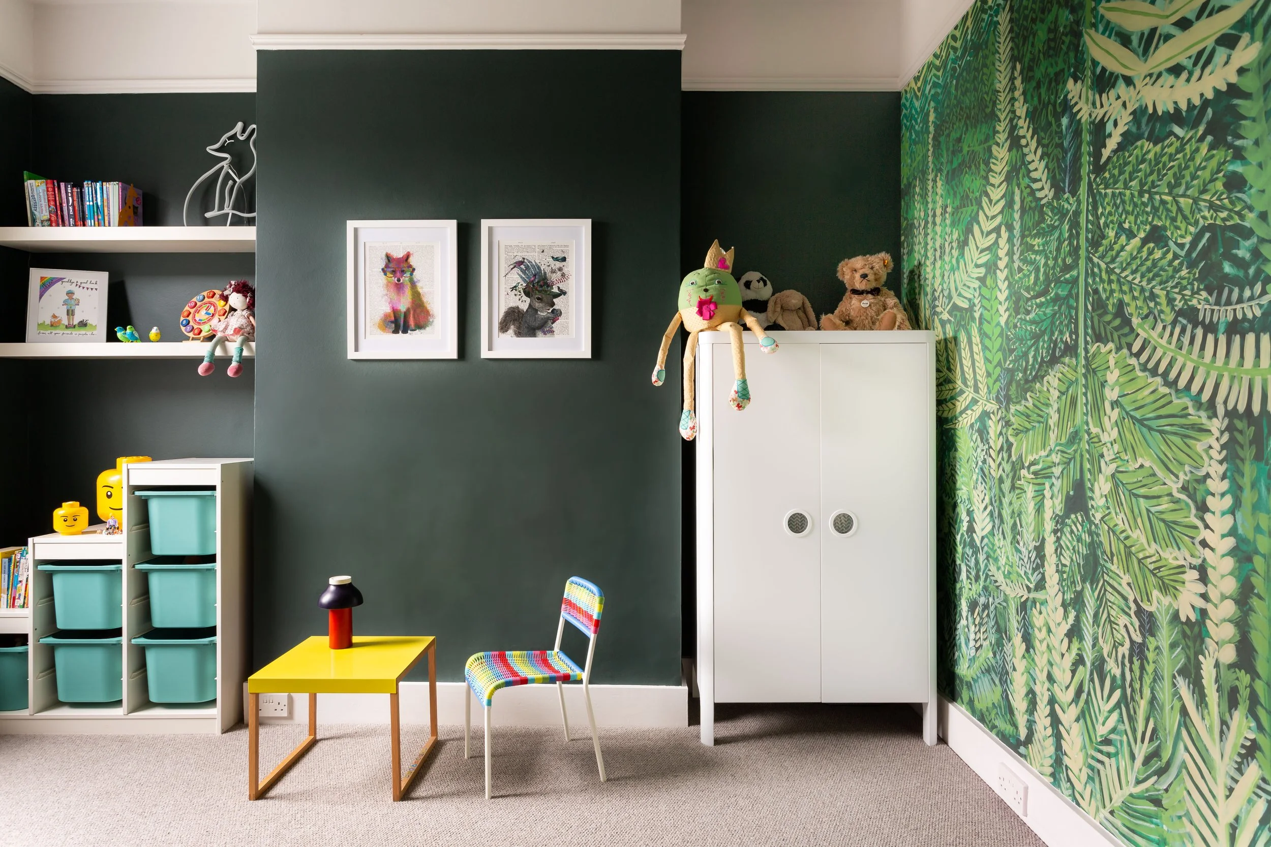 Child's bedroom with warm dark green wall and forest scene wallpaper