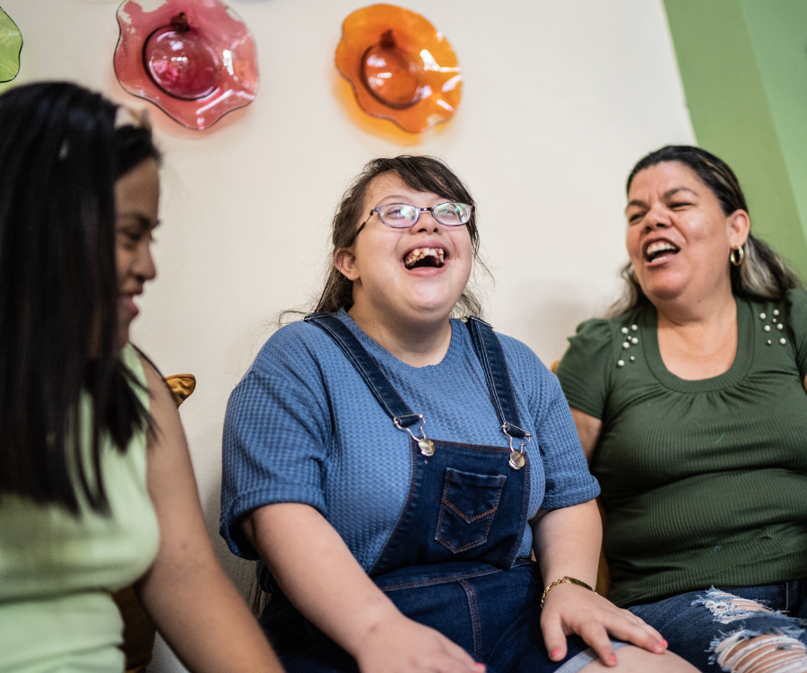 Three women with disabilities laugh together