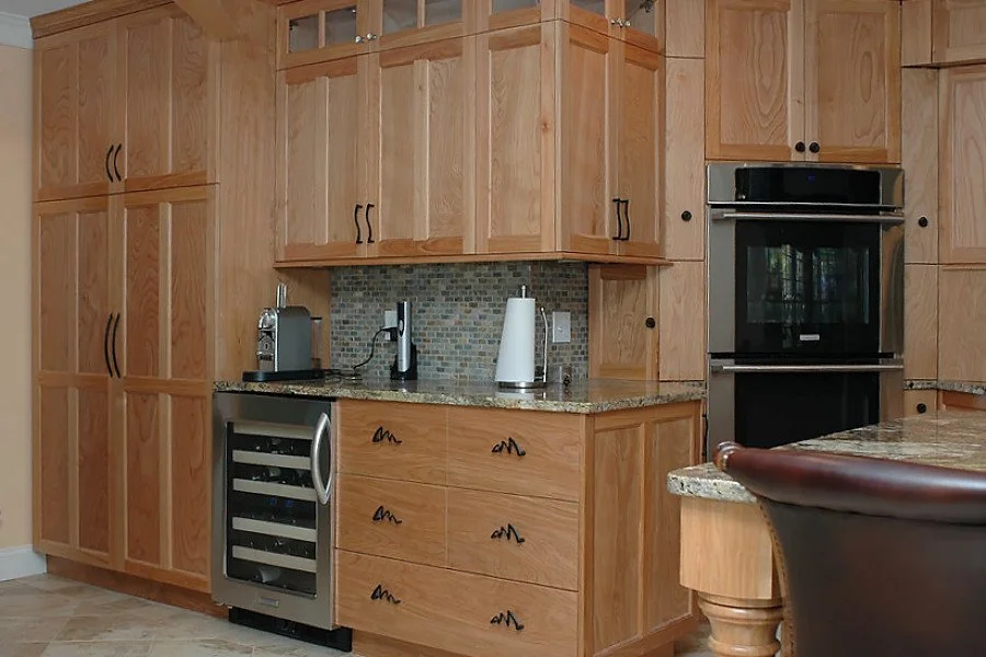 Kitchen with wooden cabinets, granite countertop, and built-in double oven. Small appliances include a coffee maker and a paper towel holder.