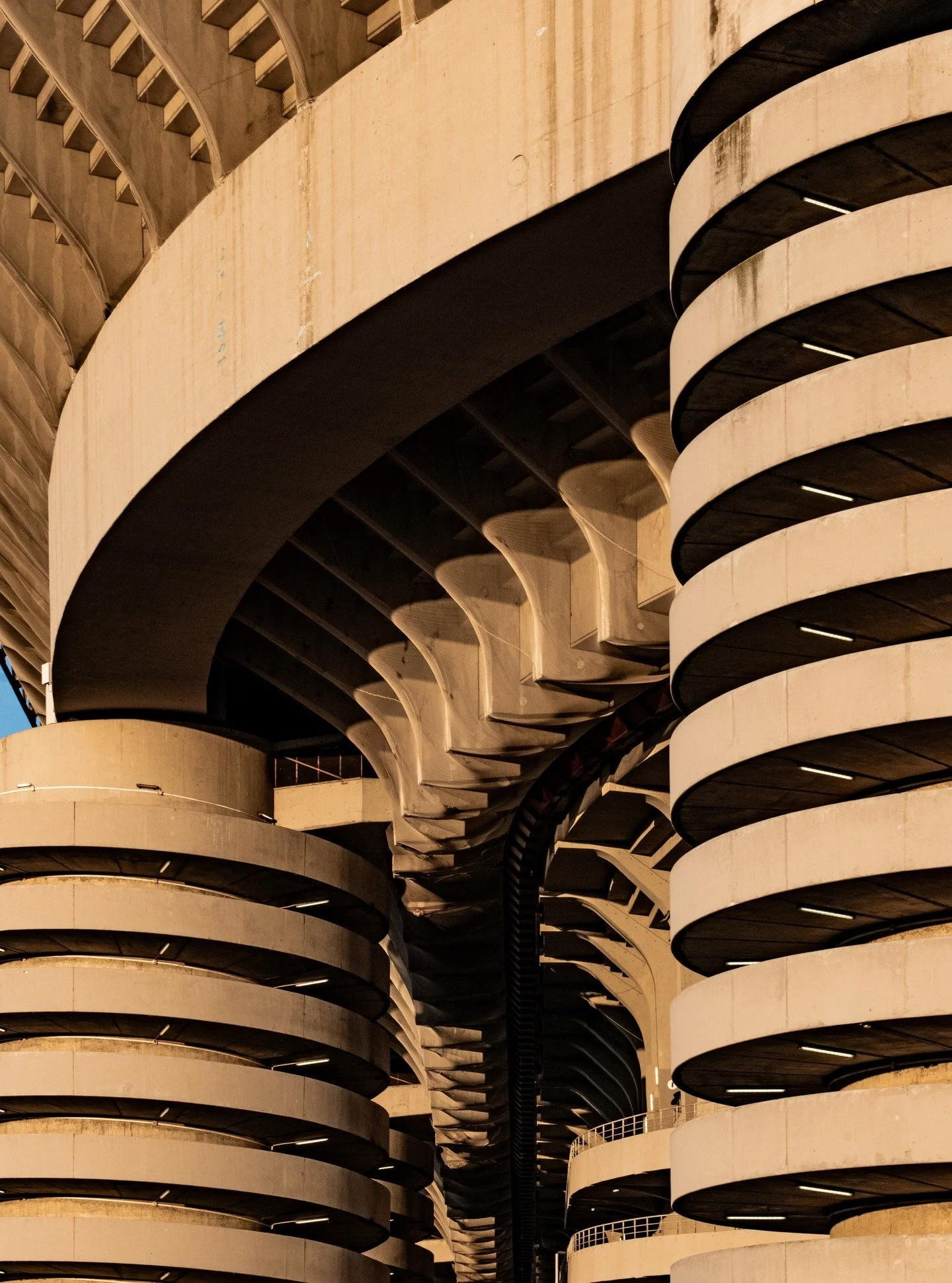 Exposed concrete as both structure and expression.

A recent visit to Milan offered the chance to study San Siro beyond the pitch; starting with its exterior structure.

San Siro reveals itself through raw materiality. A lattice of concrete cylinders