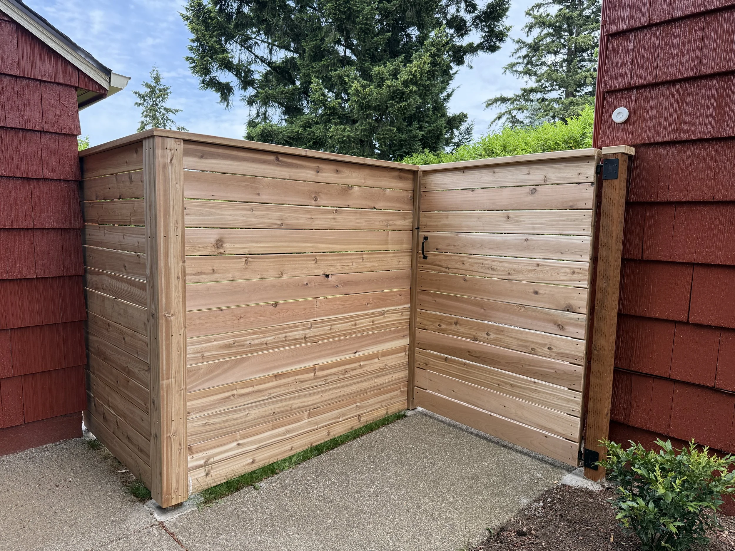 Modern horizontal cedar privacy fence with matching gate, featuring premium cedar boards, clean horizontal lines, and concealed framing at a Portland residential property.