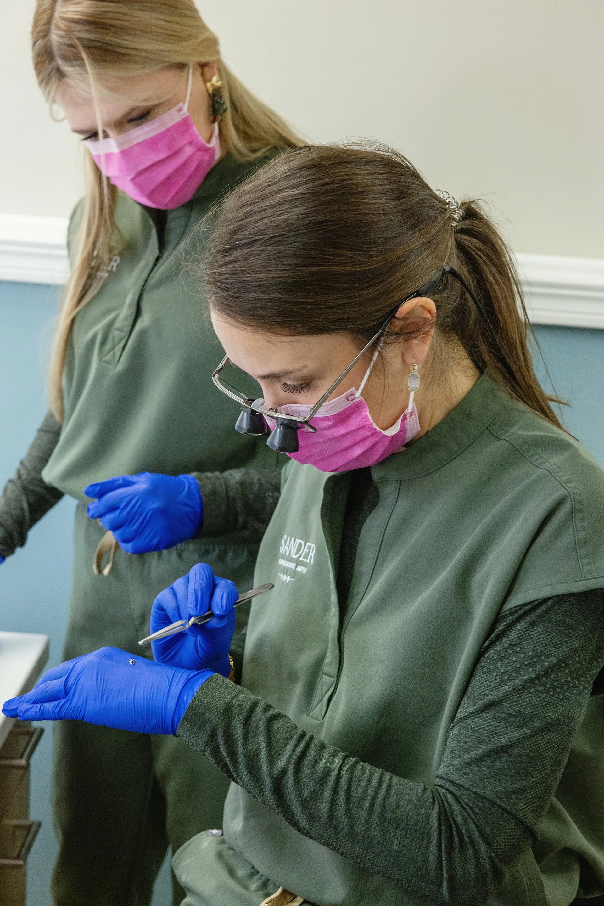 Sander Orthodontic Arts team member using loupes and tweezers to place an orthodontic bracket during a patient appointment in Andover, Kansas.