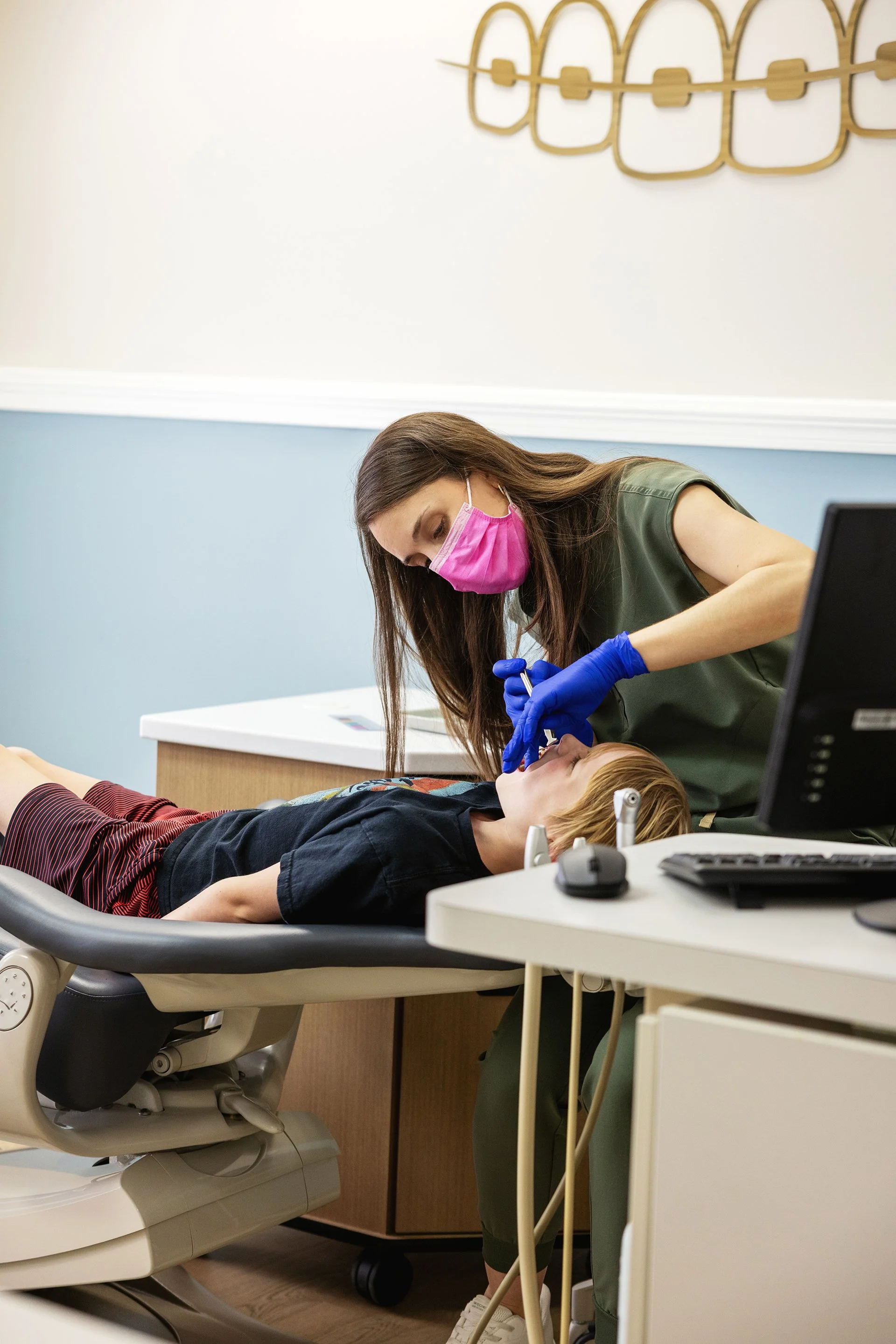Orthodontist examining a seven-year-old child's teeth during an early orthodontic evaluation.