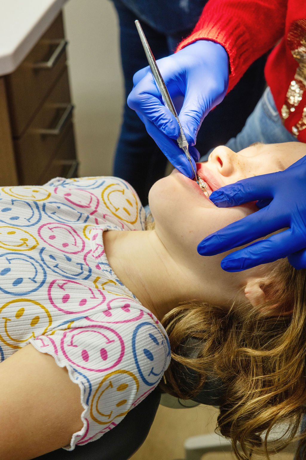Orthodontist adjusting braces on a young patient, showing the hands-on care and precision included in the cost of orthodontic treatment