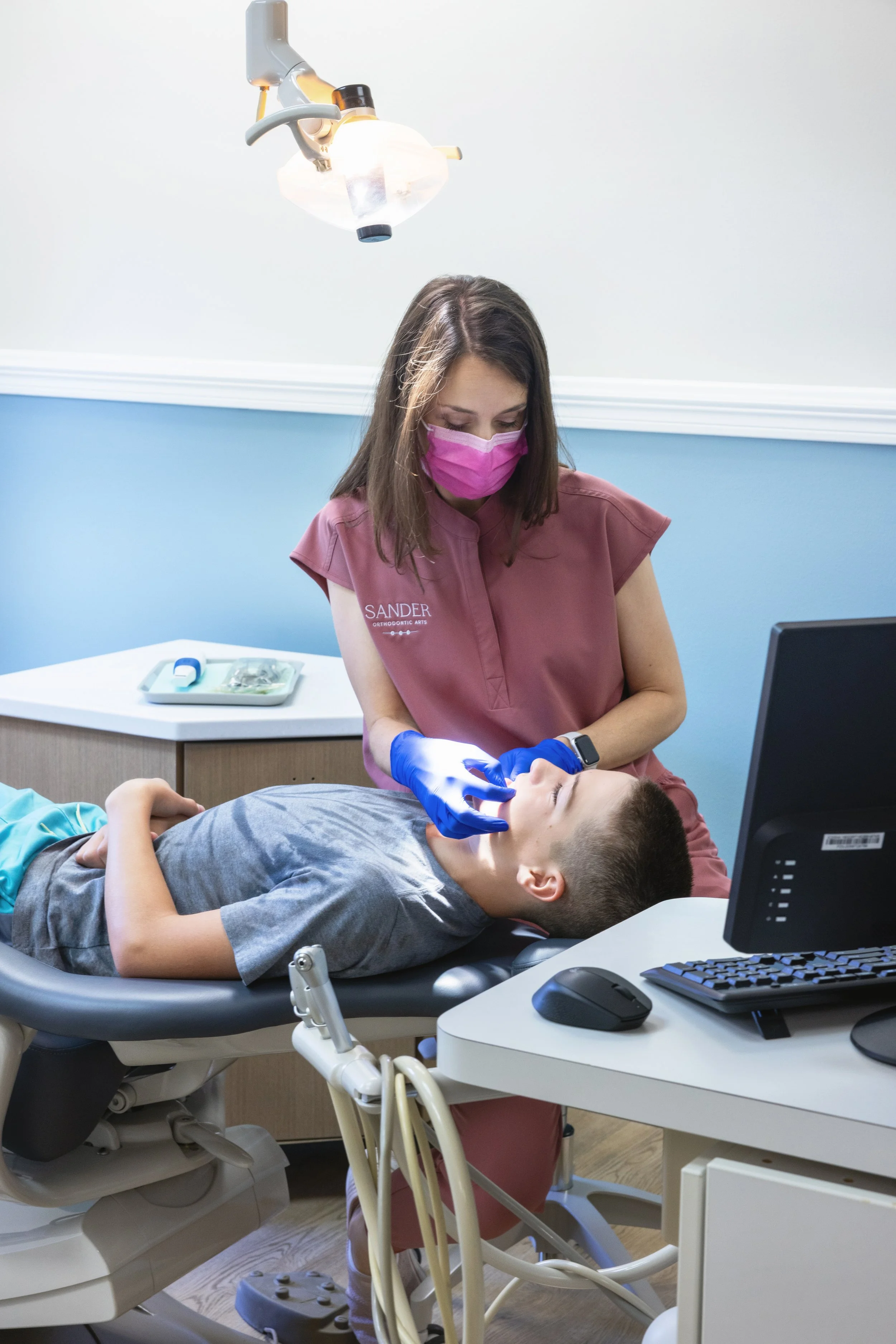 Orthodontist performing an early orthodontic exam on a young boy in Andover KS to assess dental development and determine if early treatment is needed.