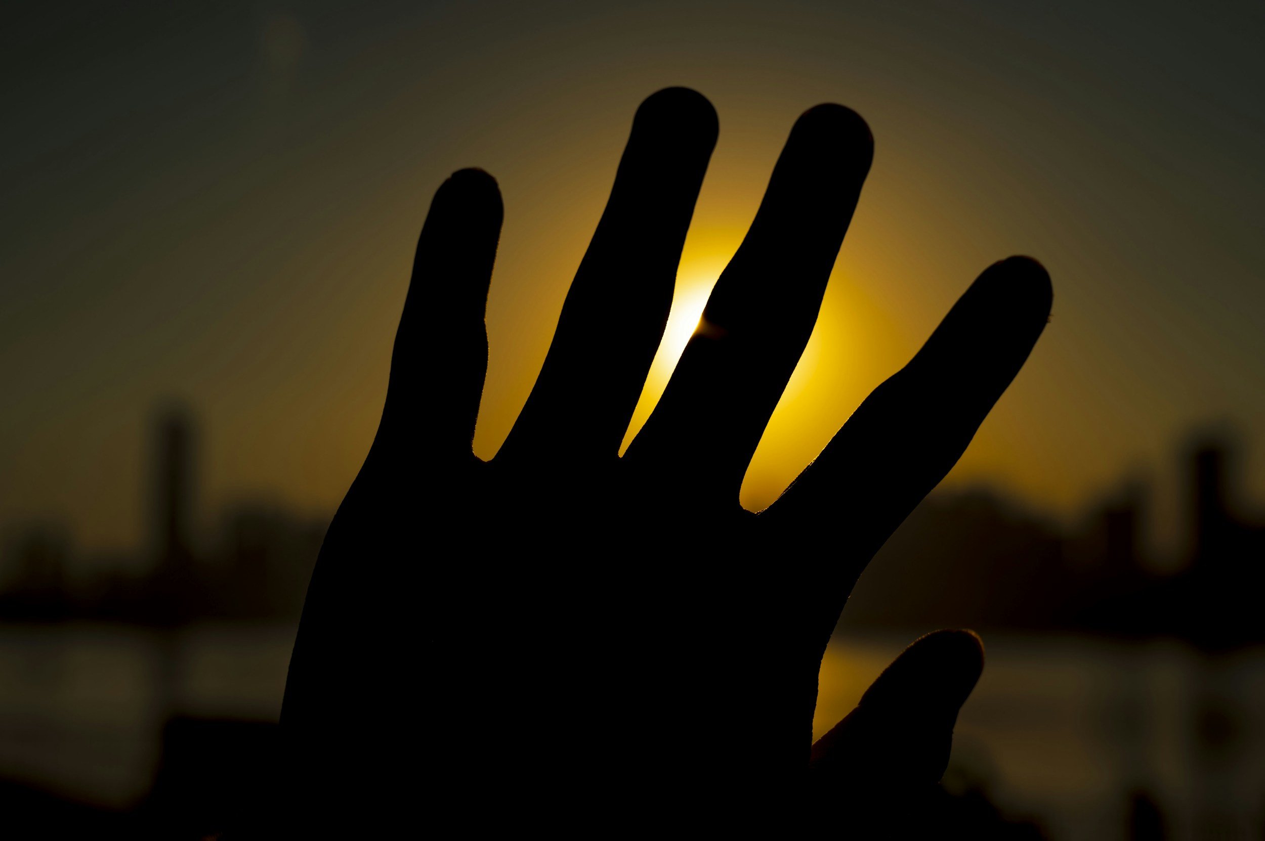 Image in silhouette of a raised hand