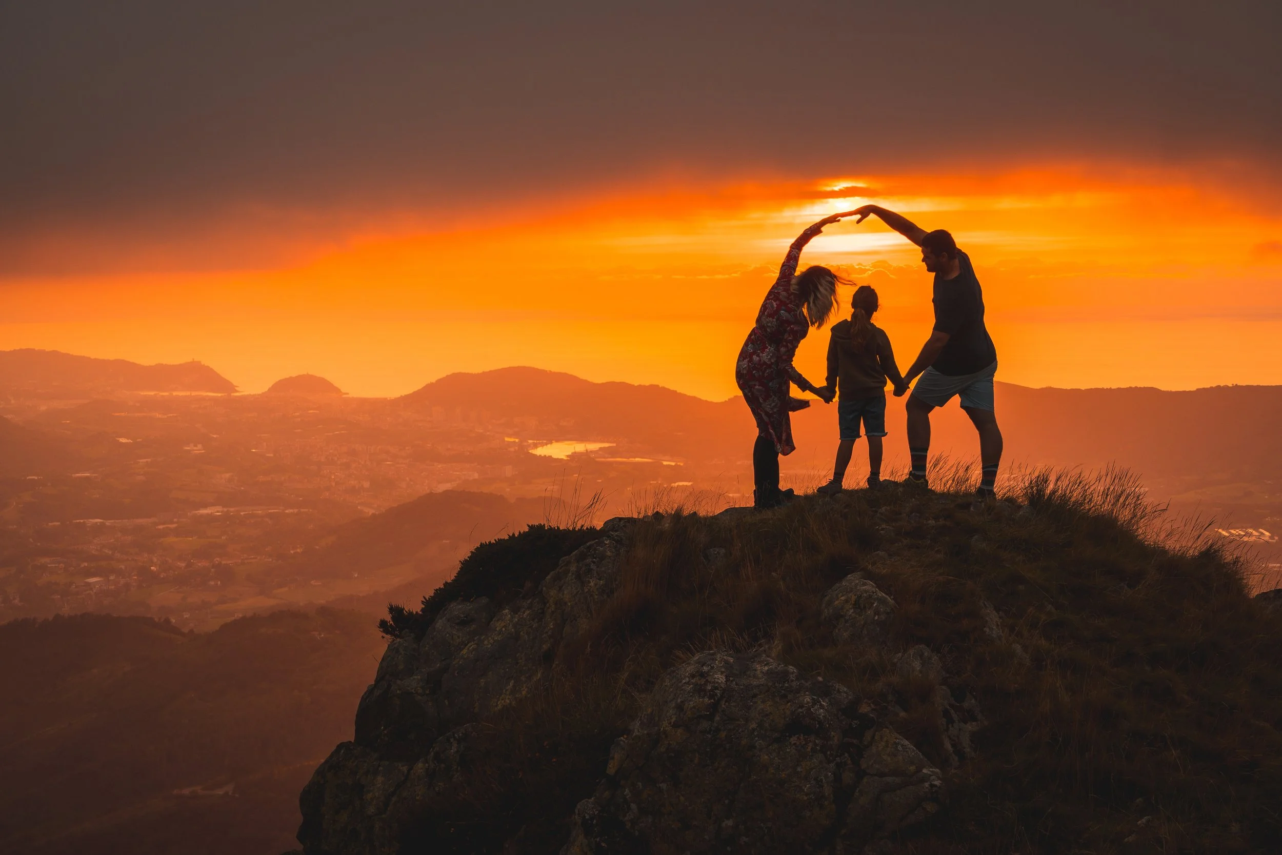 Photo of children and adults in silhouette on a hill