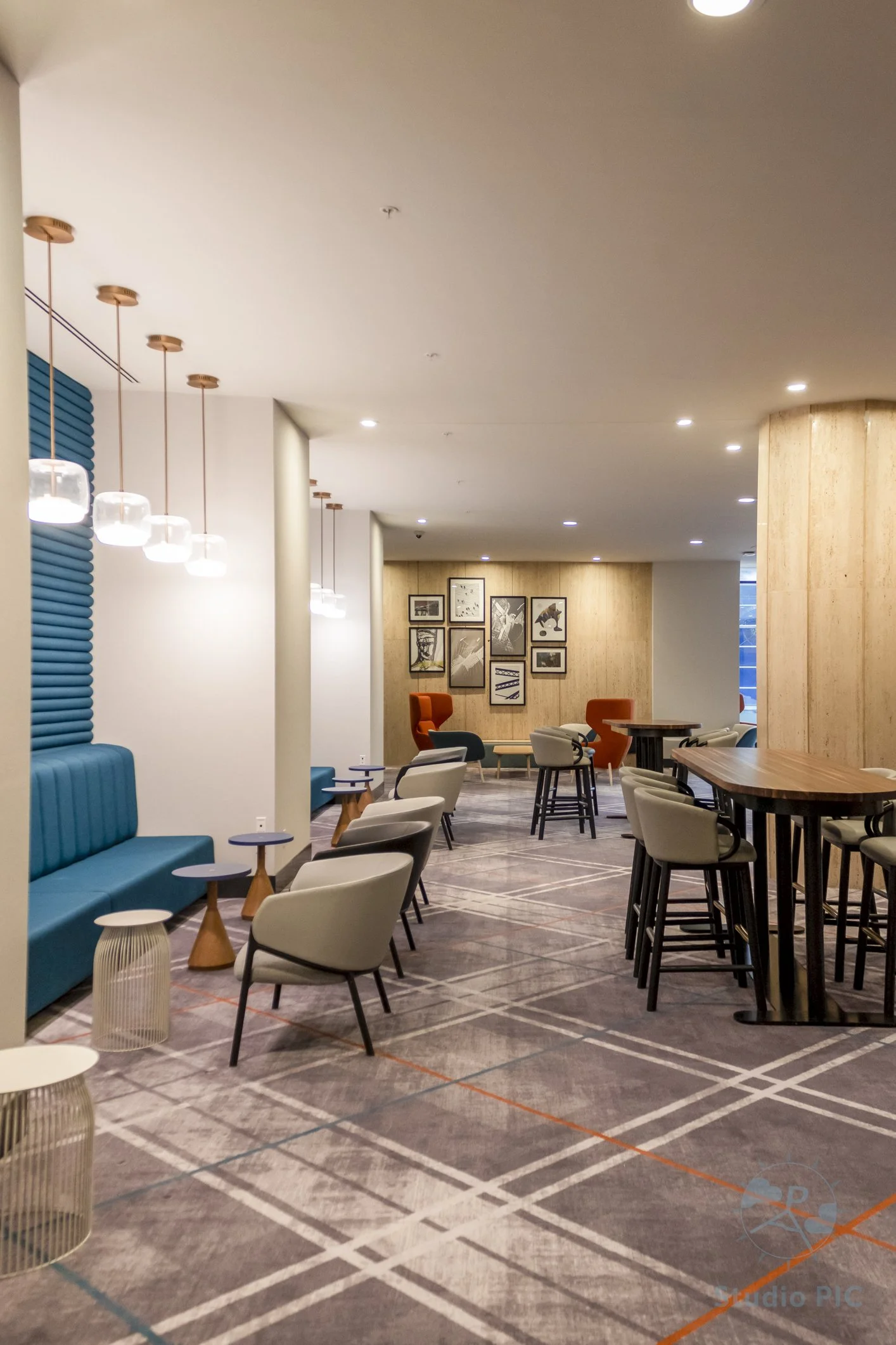 Photo immobilière d'un espace intérieur d'un hôtel à Québec. Nous y voyons des banquettes, des tables et des chaises pour s'asseoir et travailler ou relaxer