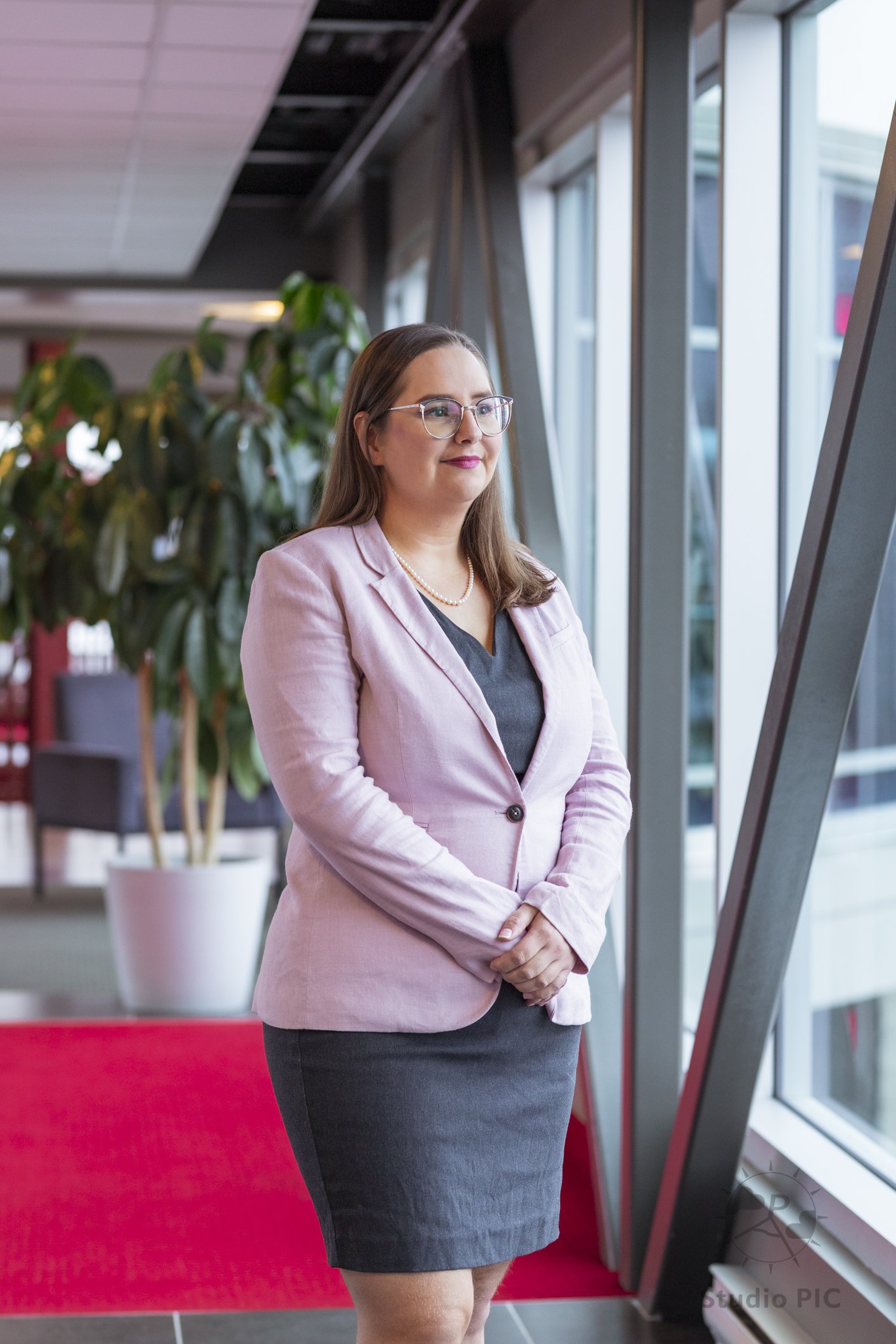 Photo de portrait corporatif d'une femme en robe grise et tailleur rose sur une passerelle à Lebourgneuf à Québec