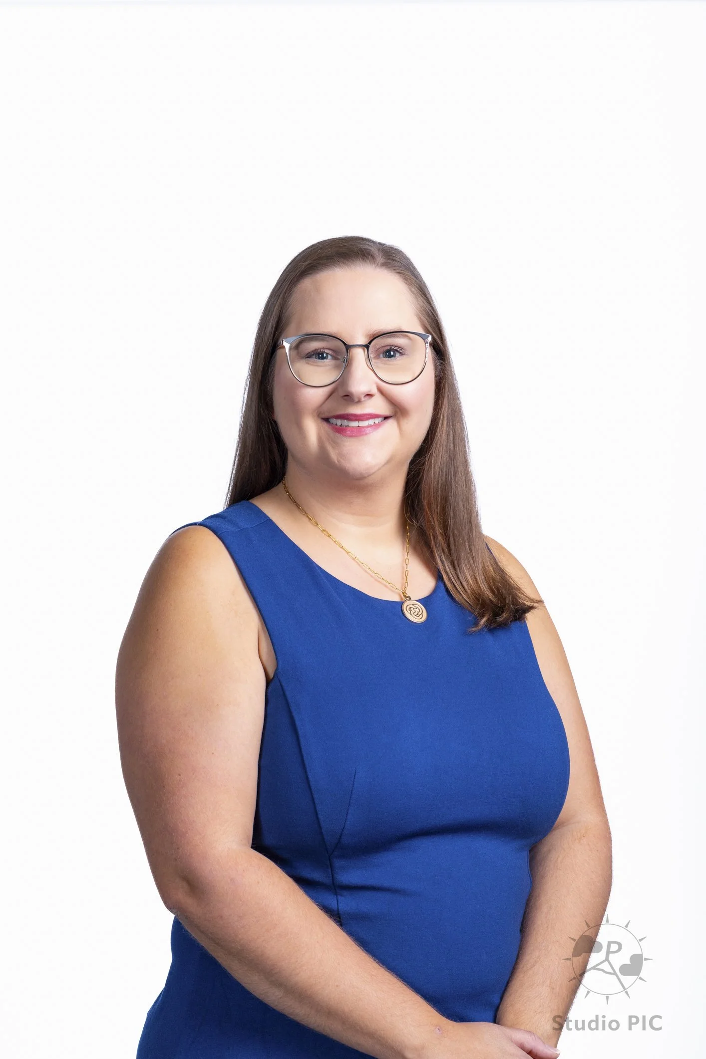 Photo de portrait corporatif d'une jeune femme en studio; portant une robe bleu et un pendentif de Primerica.