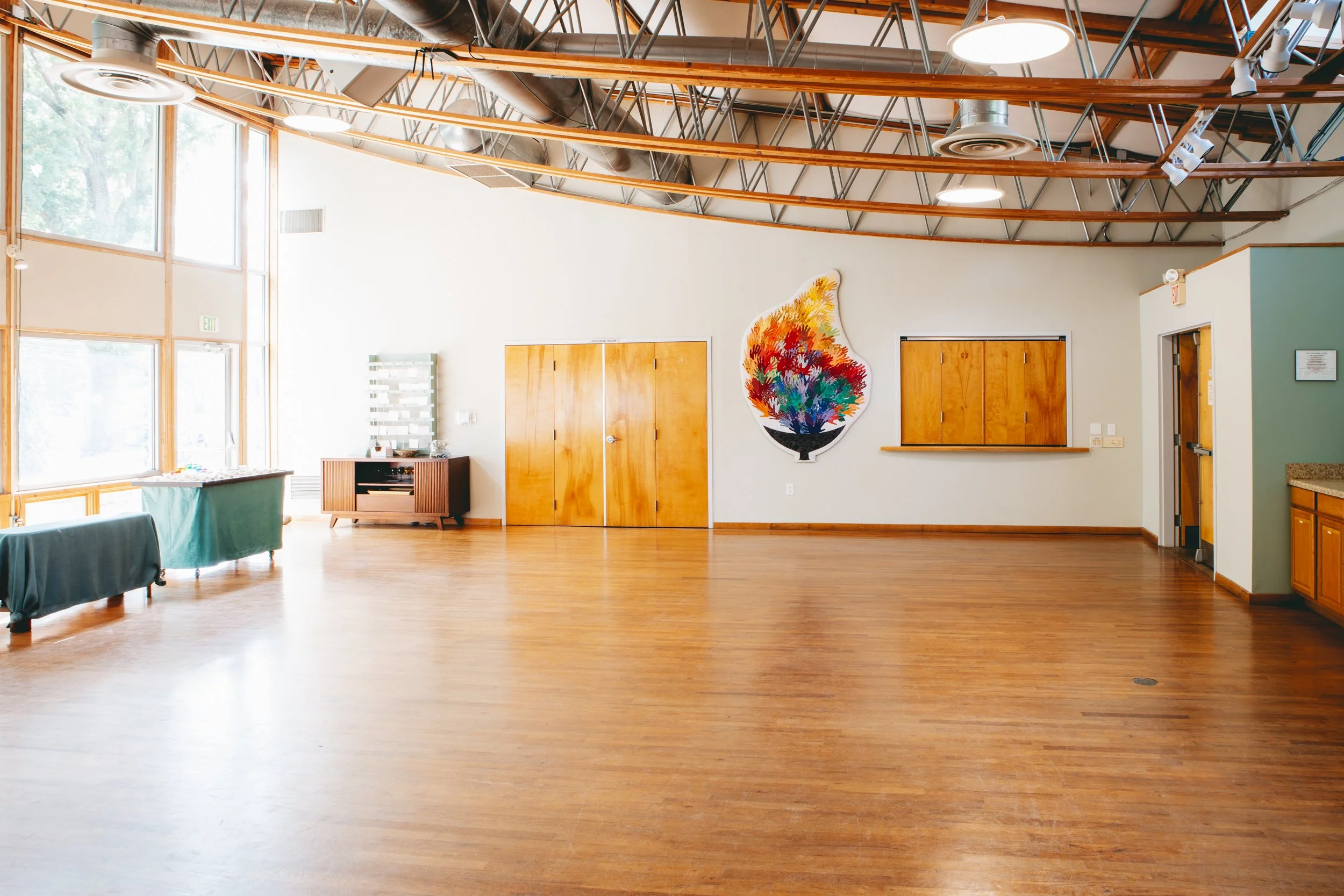 exposed rafters give an open feel to a wide open room with white walls and polished wooden floors