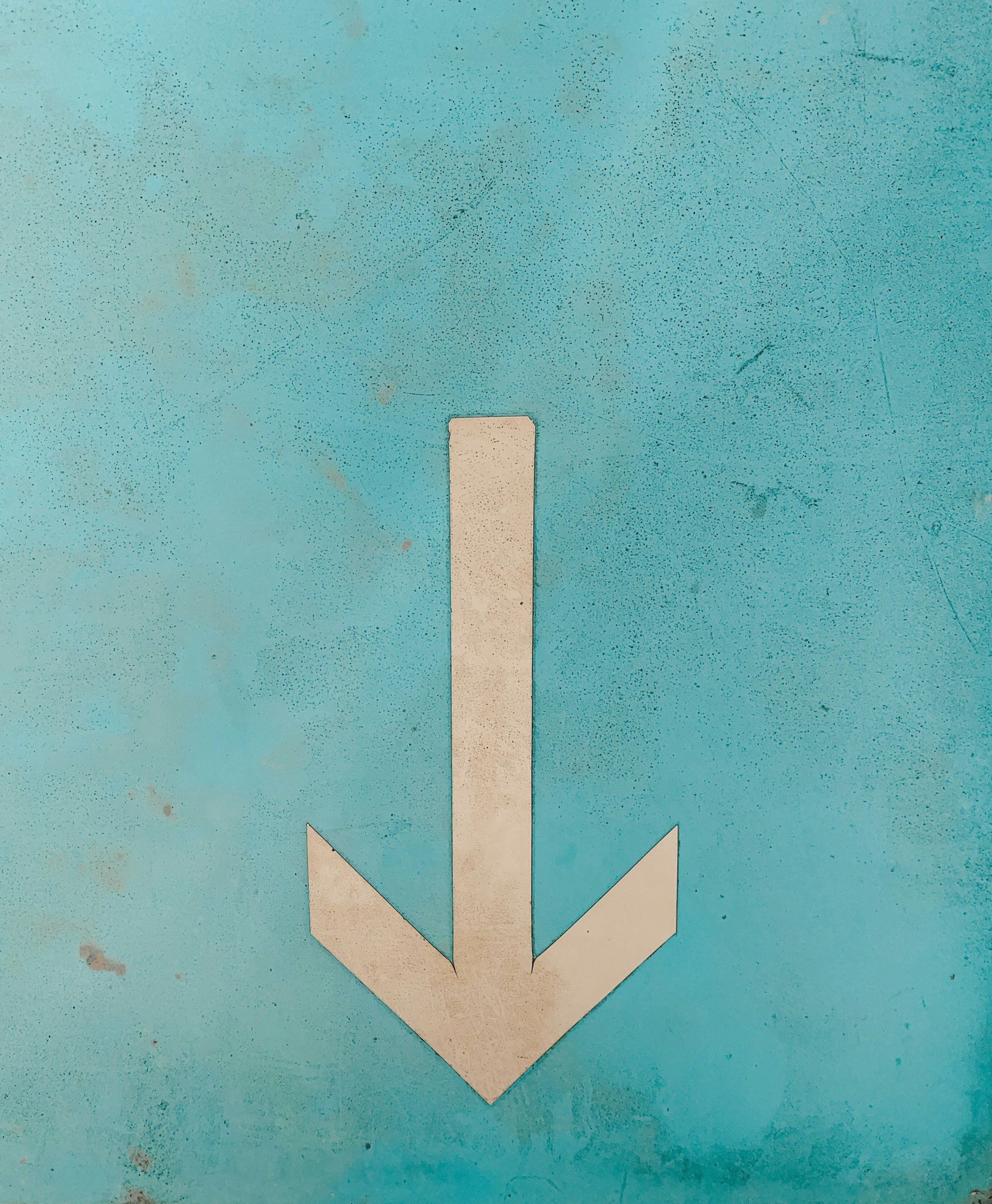 White downward arrow on a blue surface.