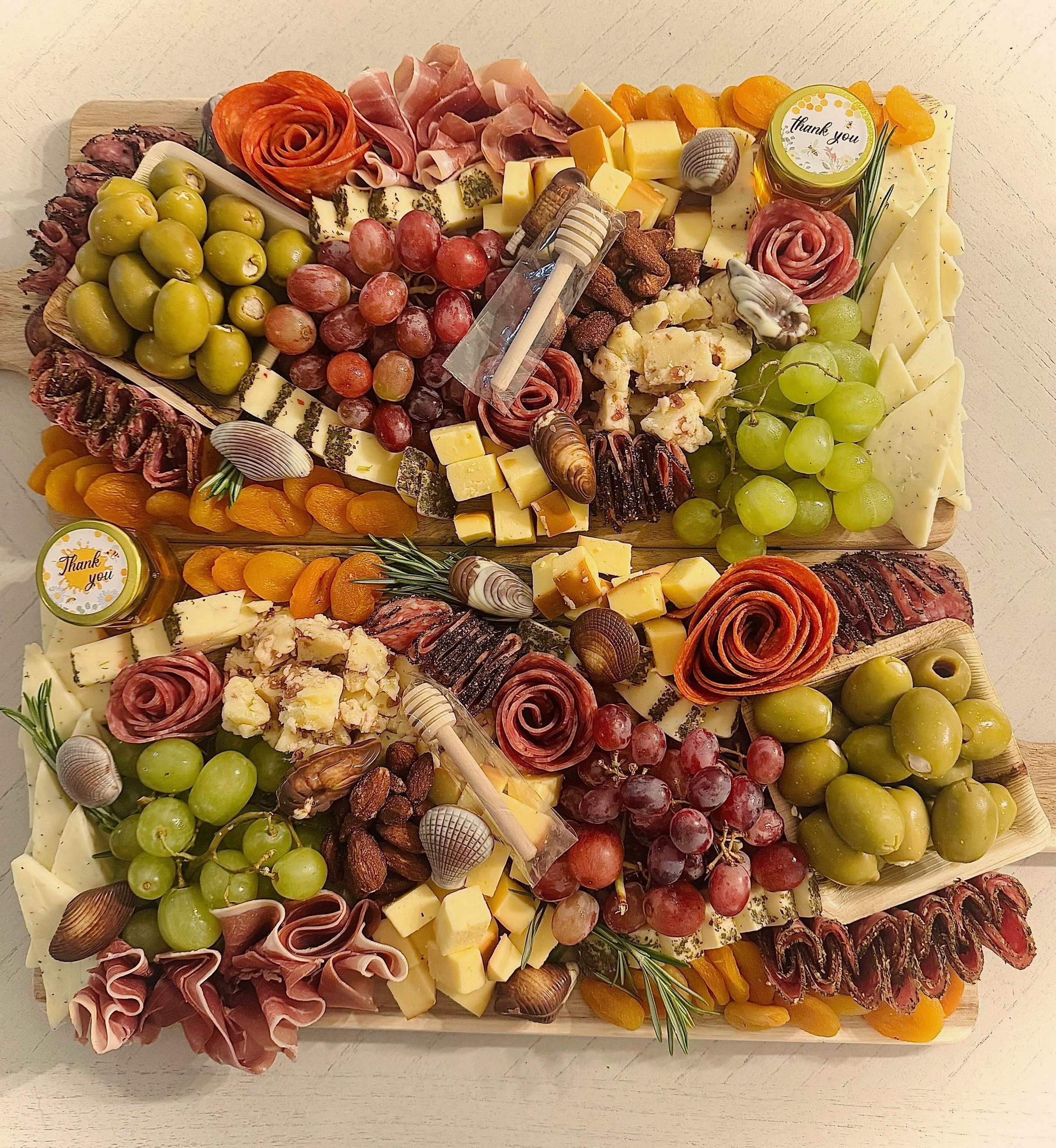 Small chocolate treat boxes decorated with strawberries, bananas, and flowers, placed on a wooden surface.