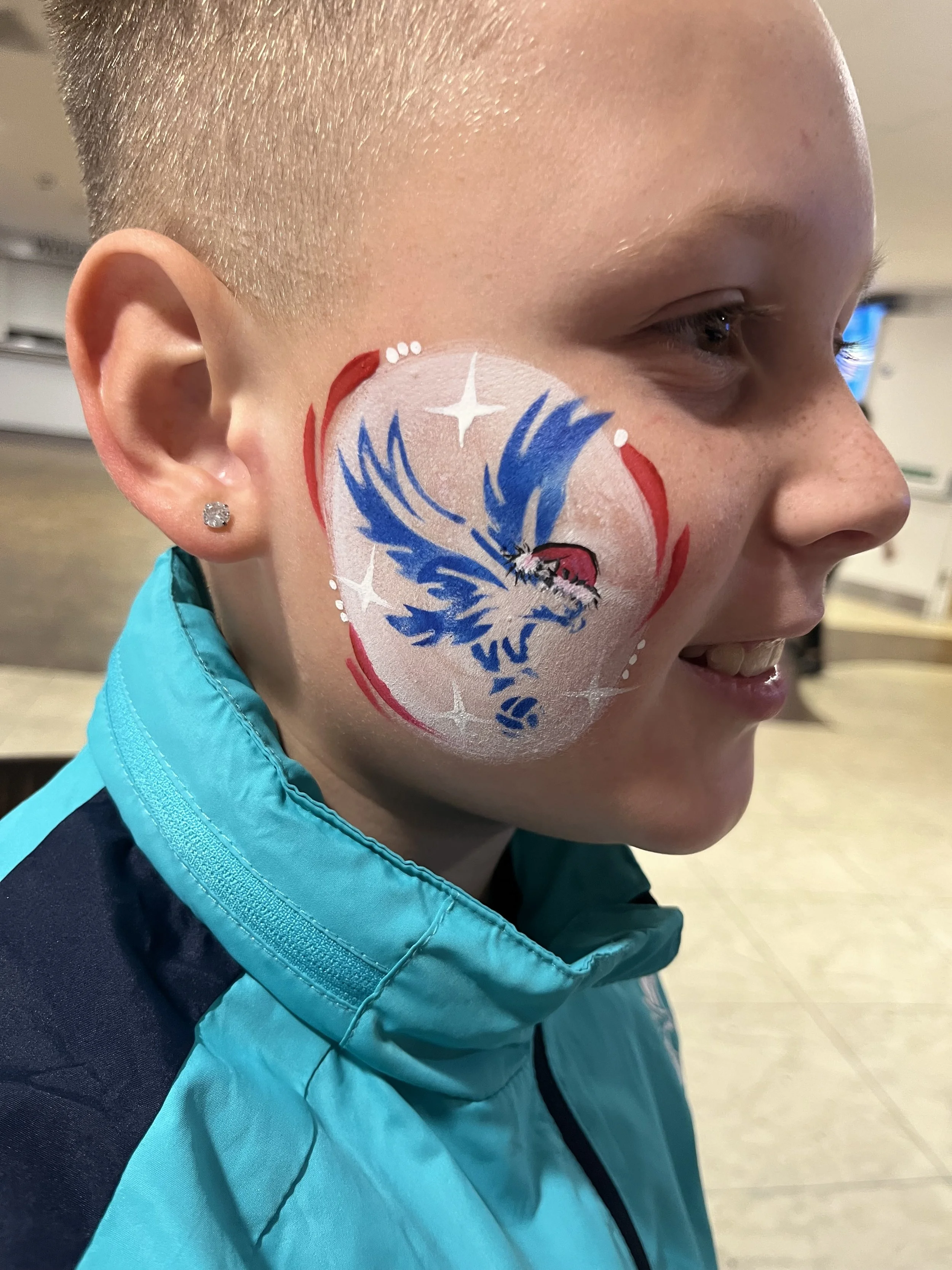 "Boy with Crystal Palace eagle face painting at a Christmas party in South London"

