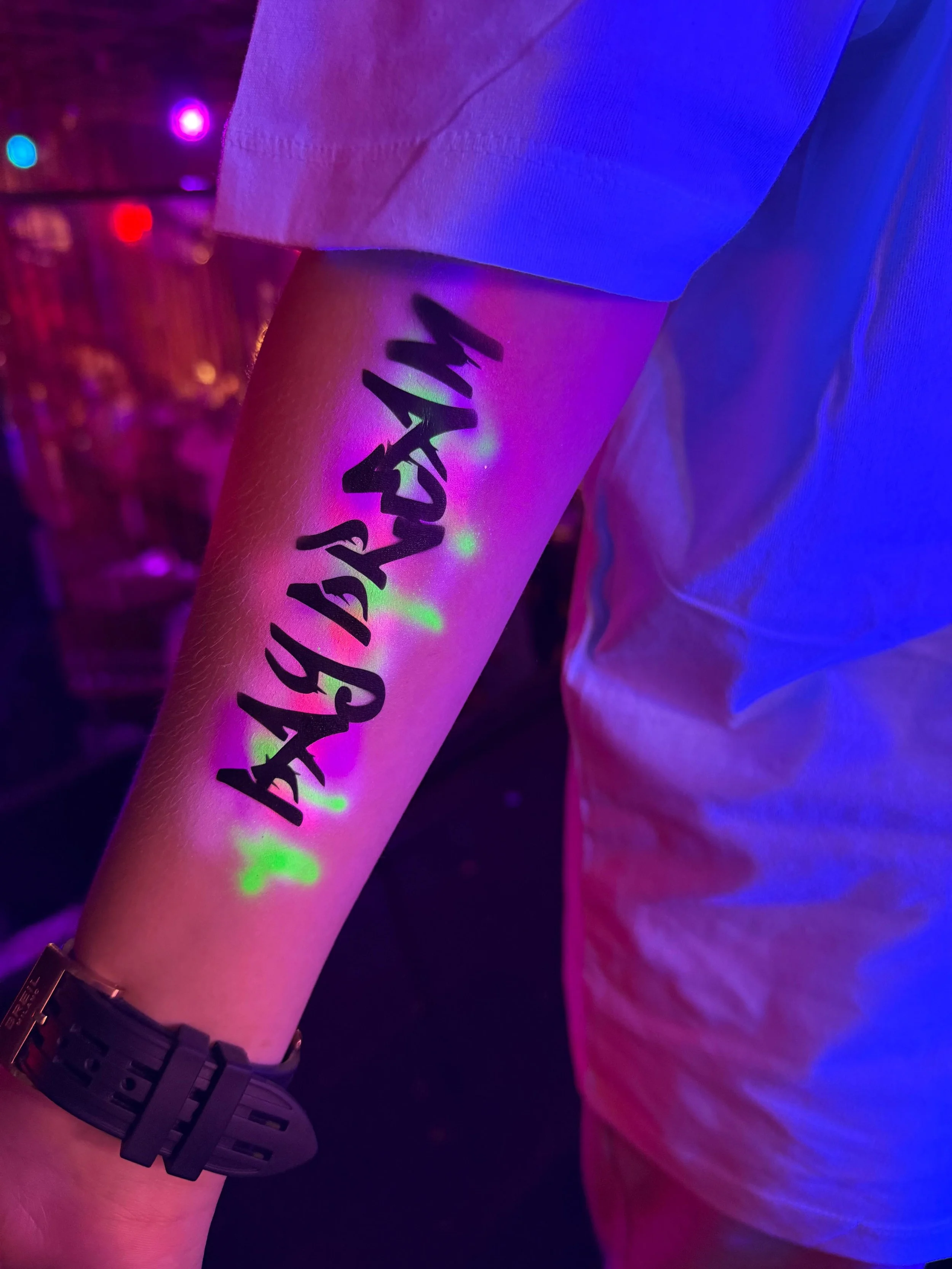 Professional airbrush artist creating safe, temporary tattoos at an educational fair"