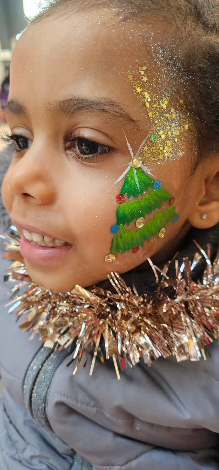 "Employees enjoying holiday face painting at South London company event"

