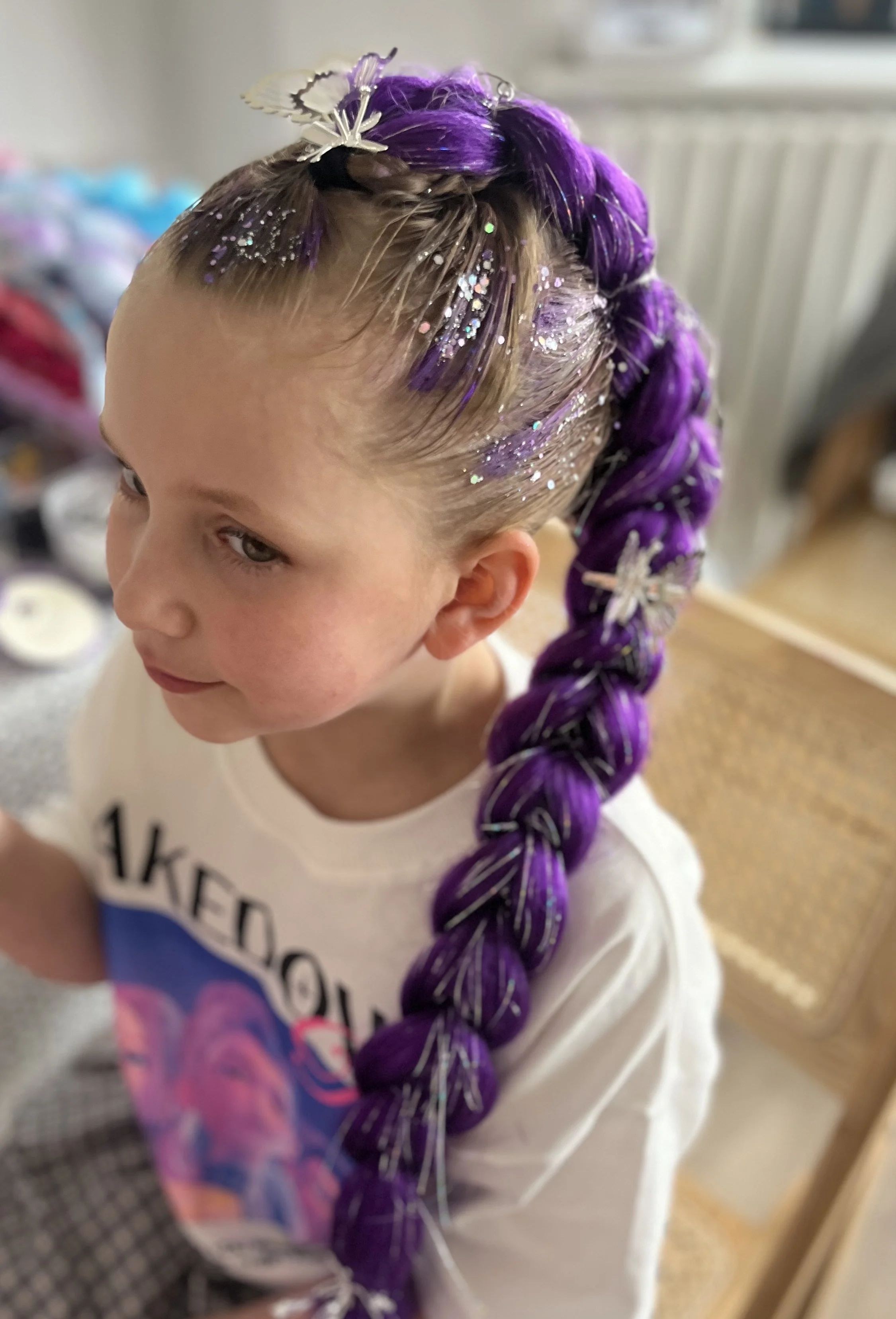 “Children’s party hair styling with colourful braids at an event in South London.”