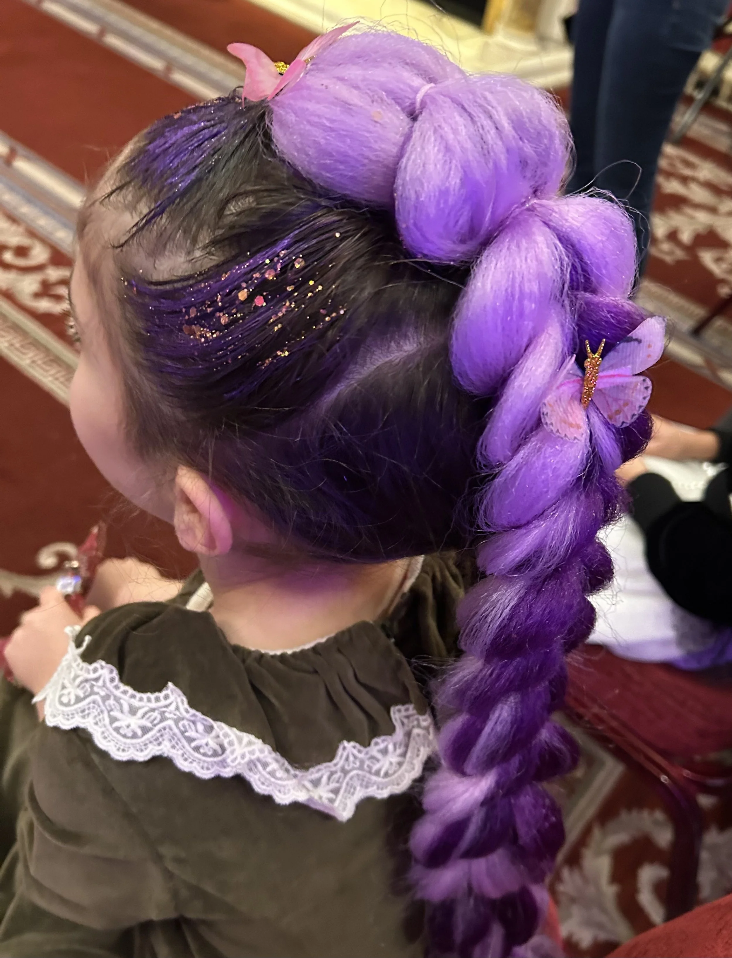 Children’s hair stylist braiding hair at a London party
