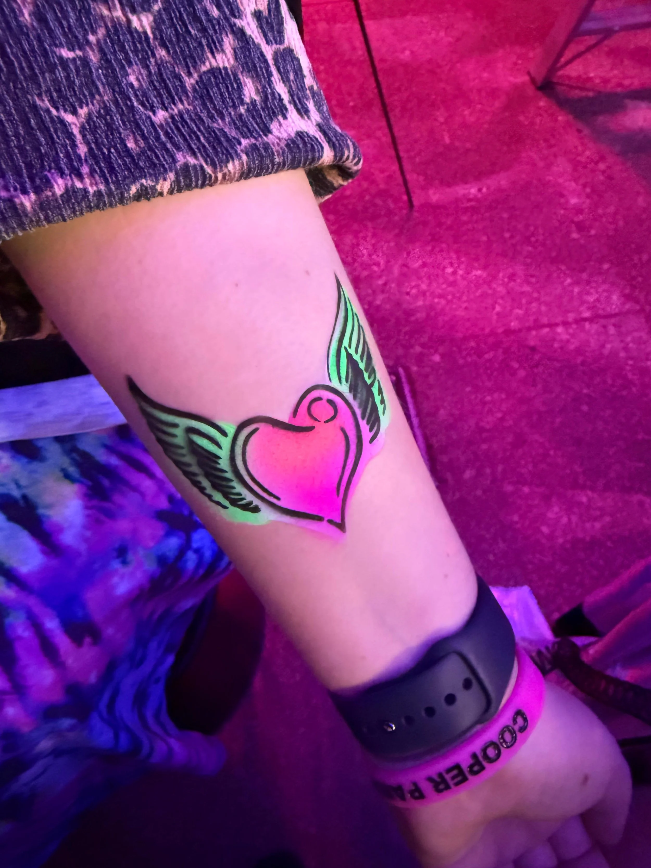 Children and adults enjoying airbrush tattoos at a London event