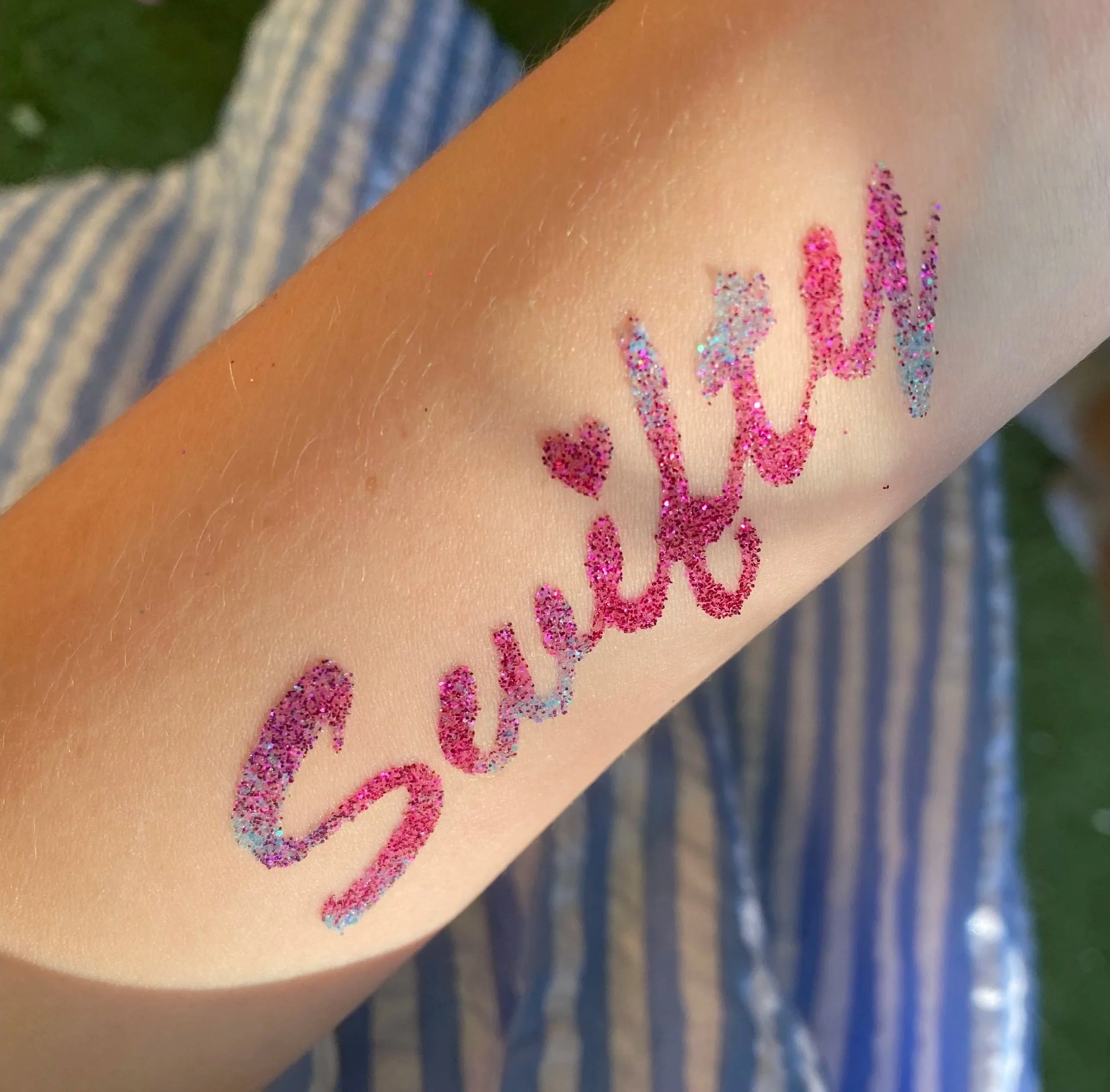 “Festival‑style glitter face designs for children at a party in West London.”