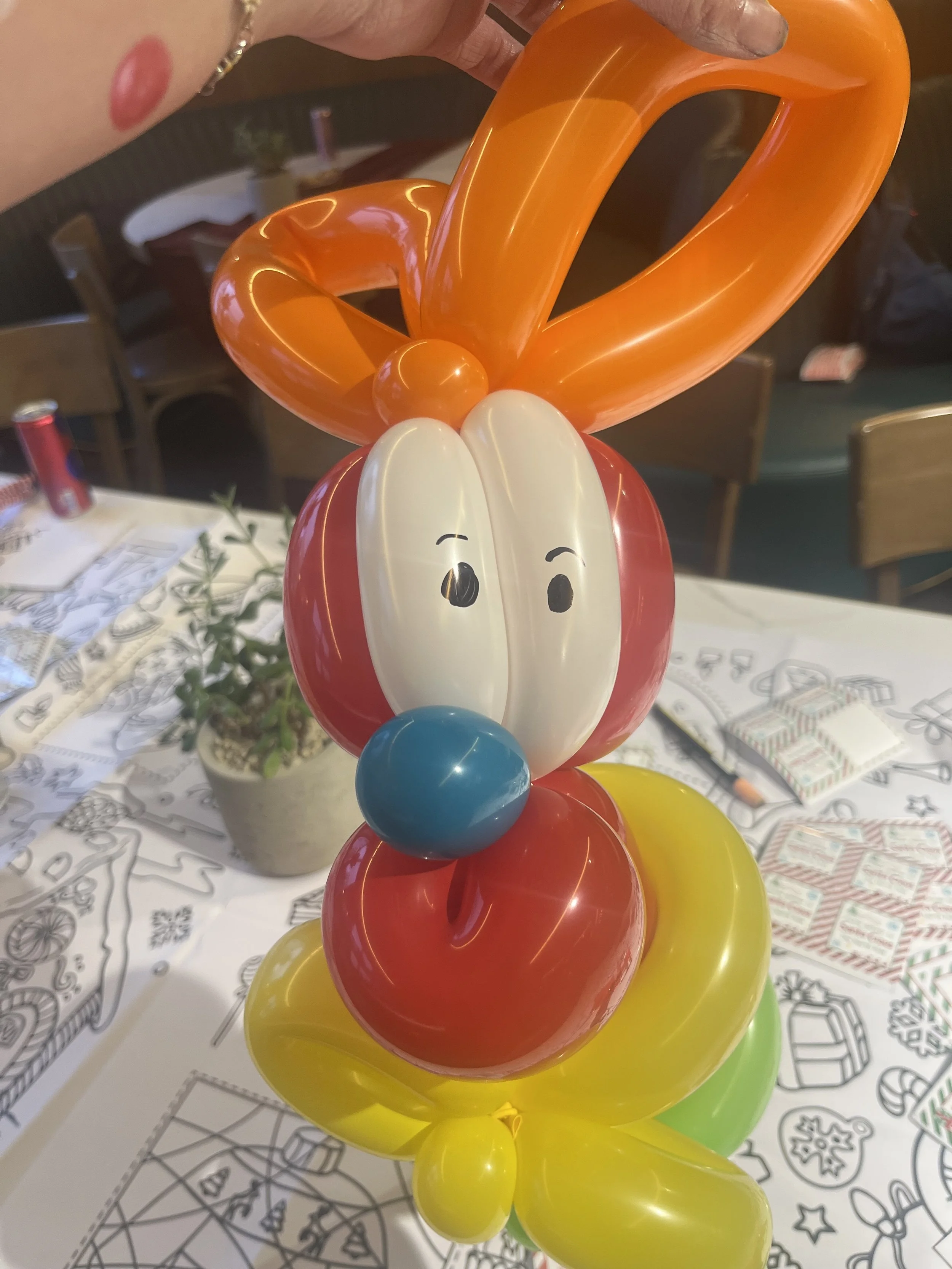 "Balloon twisting entertainer creating balloon animals for children in West London"