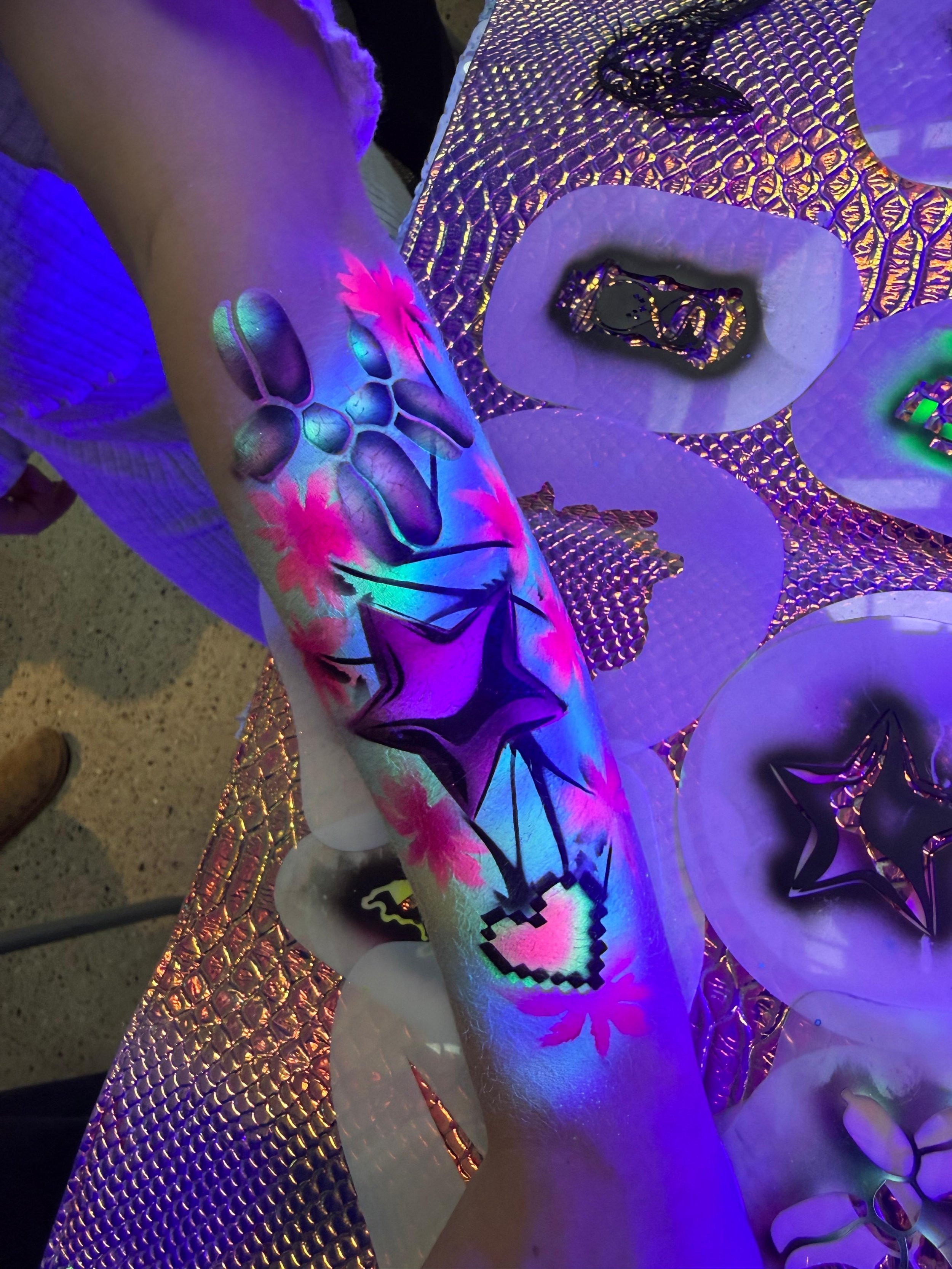 "Students enjoying temporary airbrush tattoos at a school or university event"