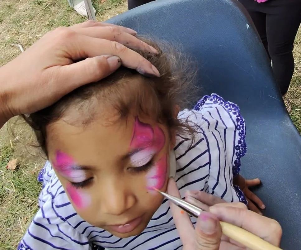 Children enjoying colourful face painting at a party in Hammersmith and Fulham