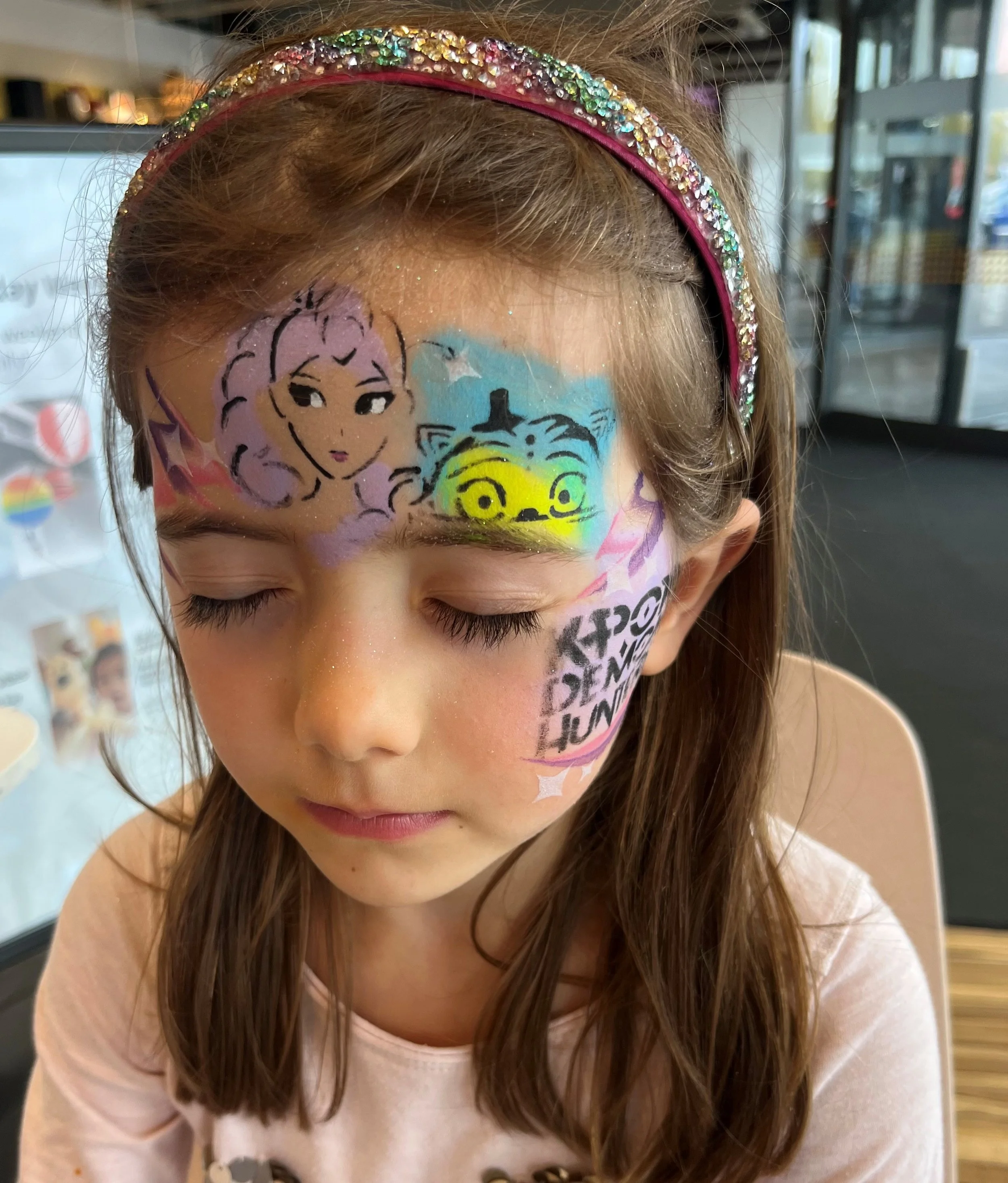 Professional face painter entertaining children at a Chelsea event