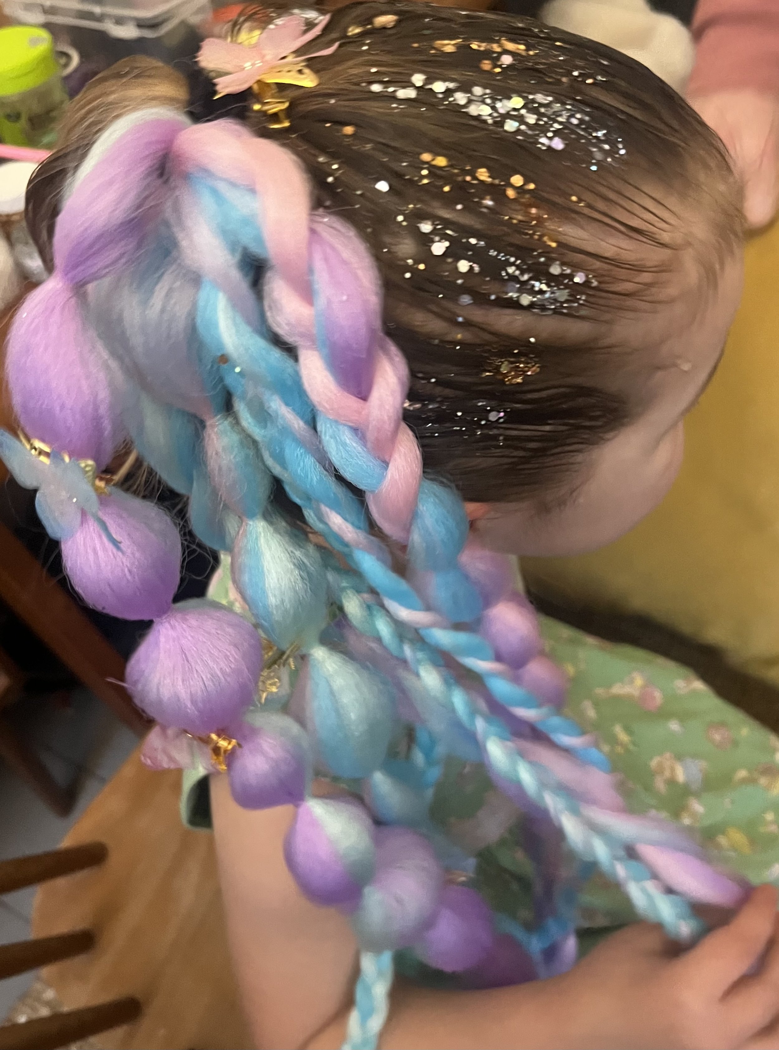 "Child having a braided party hairstyle created at a family event in Kensington."
