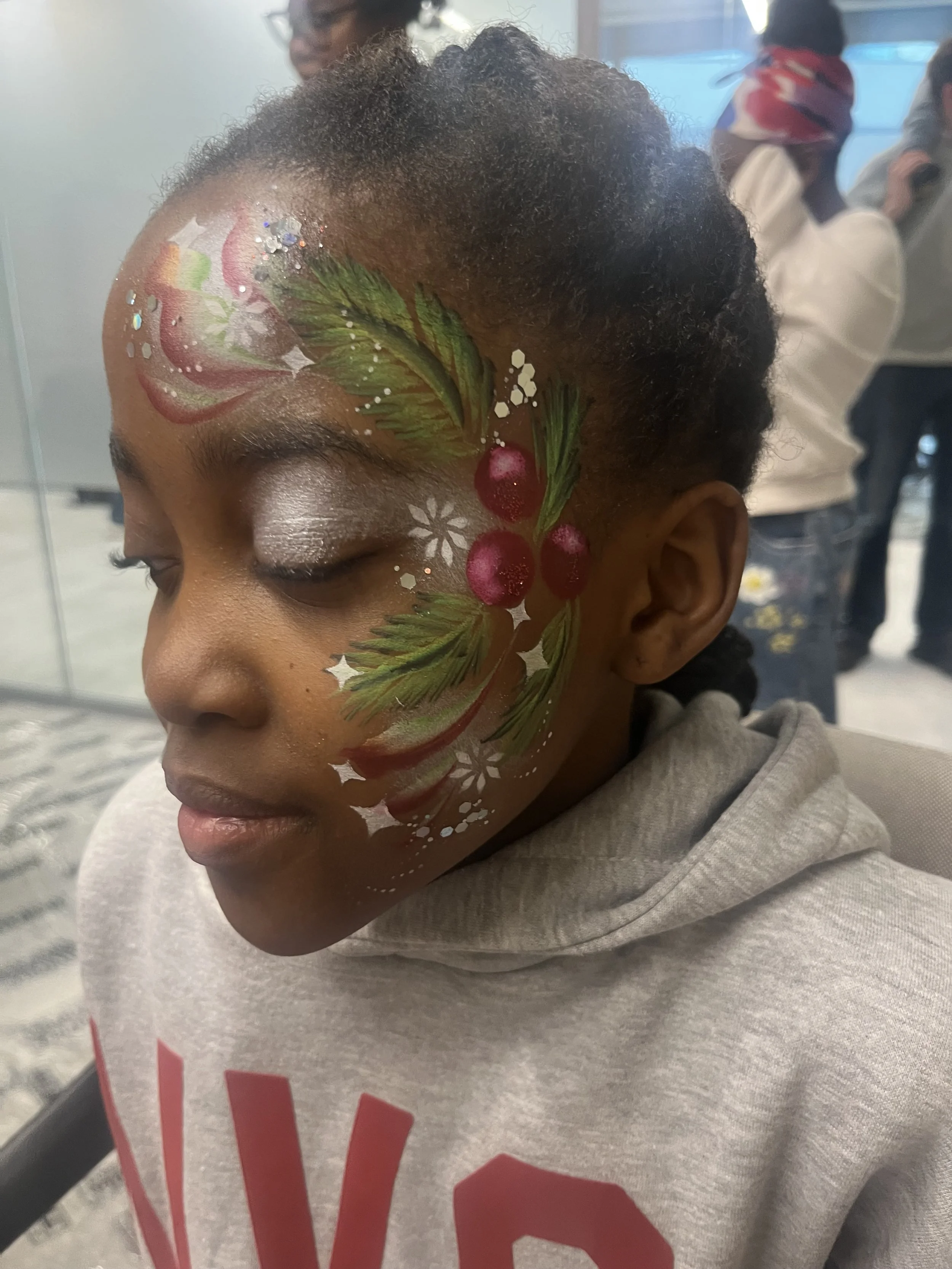 "Girl with holly and snowflake face painting at a Christmas event in West London"
