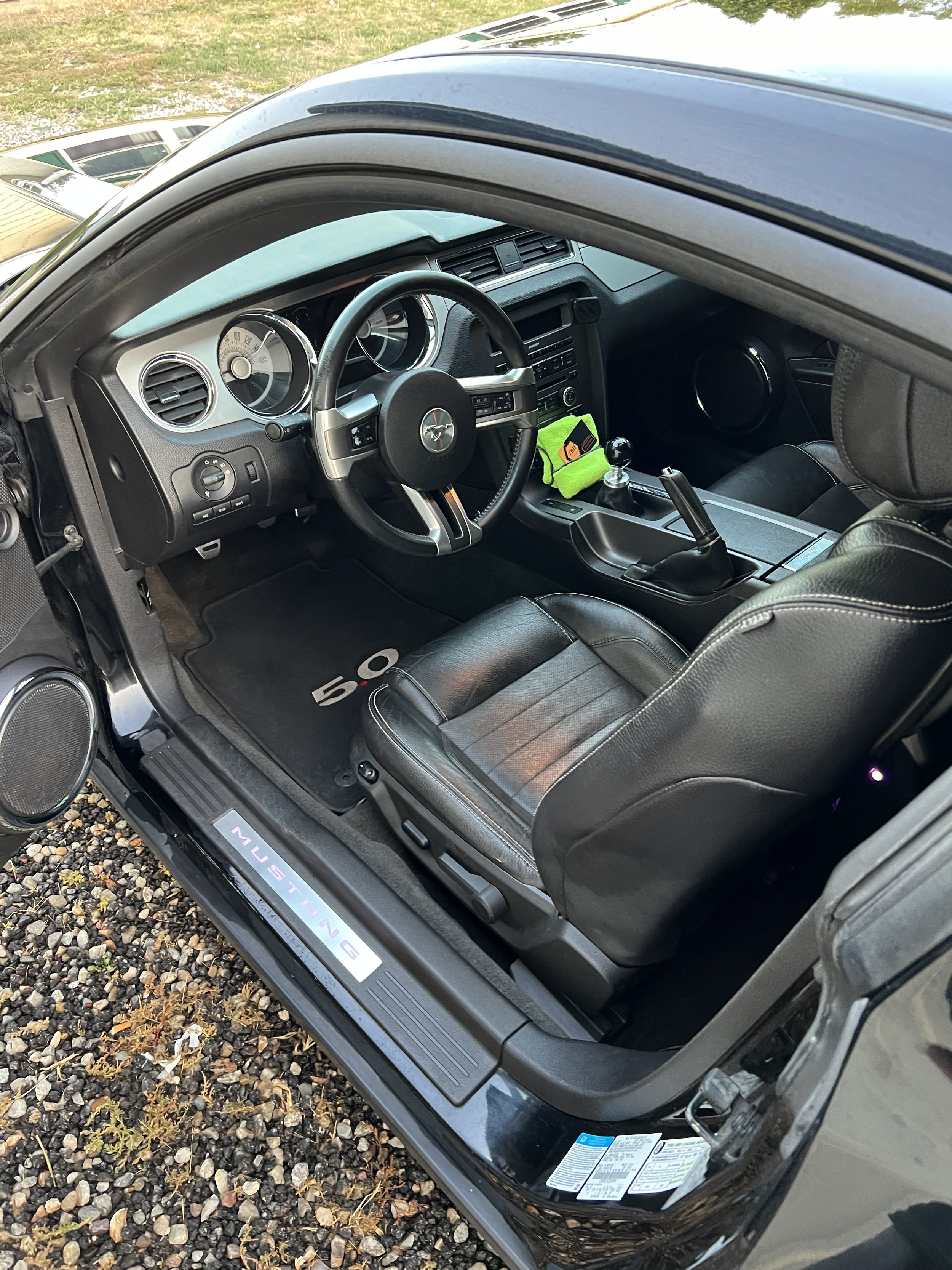 Interior of a black Ford Mustang displaying the driver's seat, steering wheel, and dashboard.