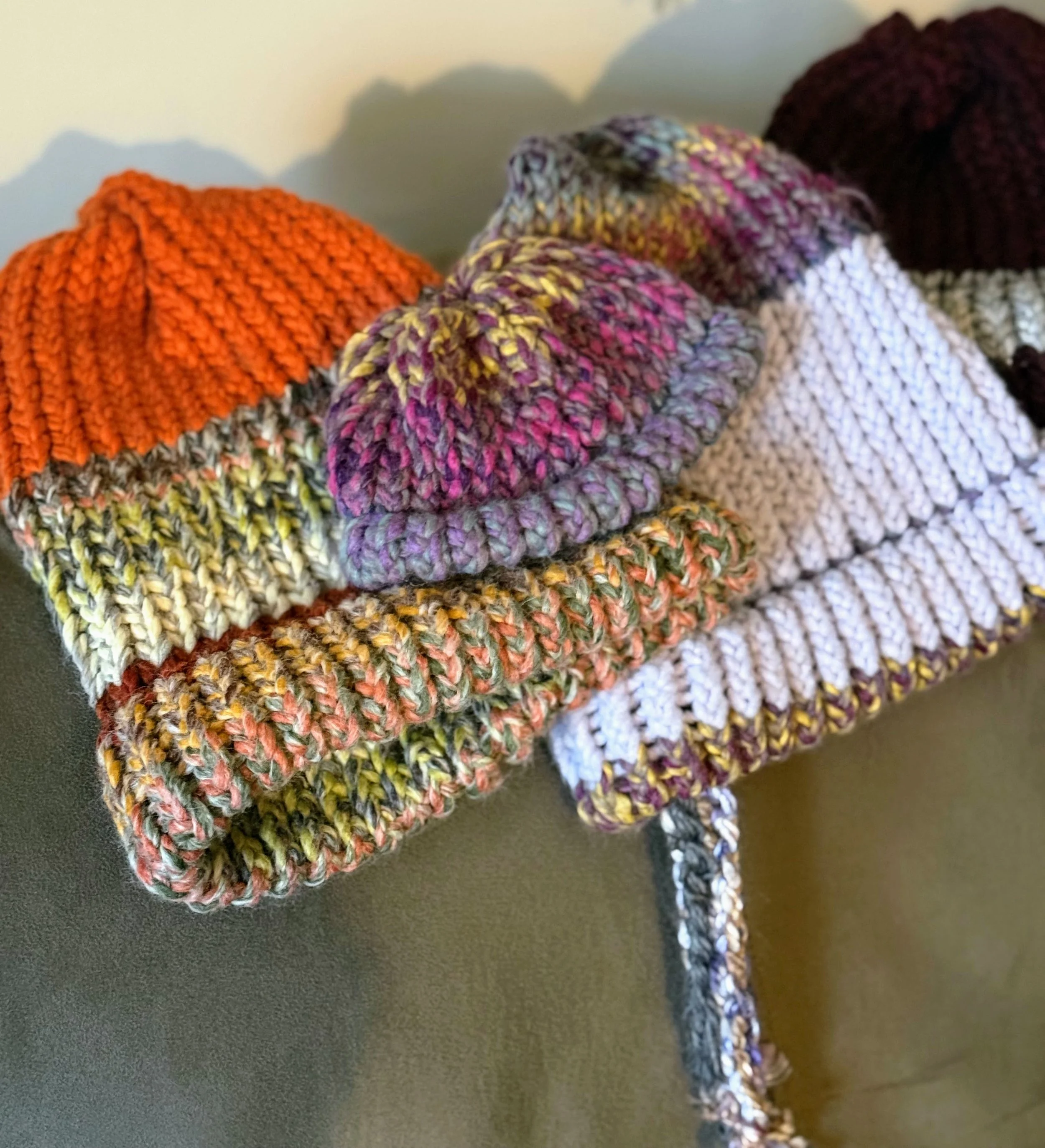 Crochet hats sitting on a chair.