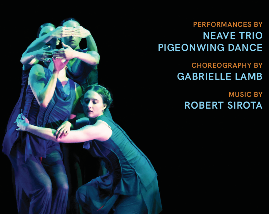 Person wearing an extravagant costume covered in flowers, pom-poms, and colorful decorations, holding a hat, in a theatrical setting.